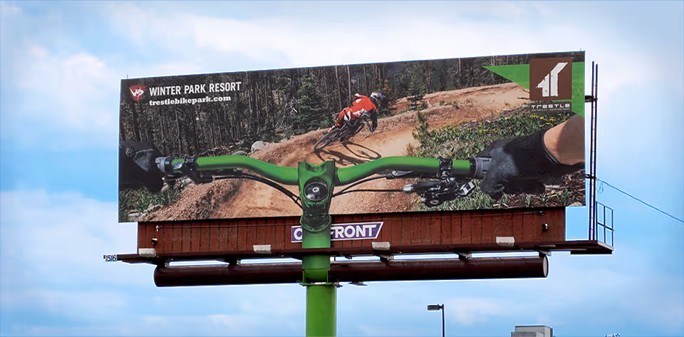 An action POV shot of a mountain biker dropping into a berm as a billboard ad 