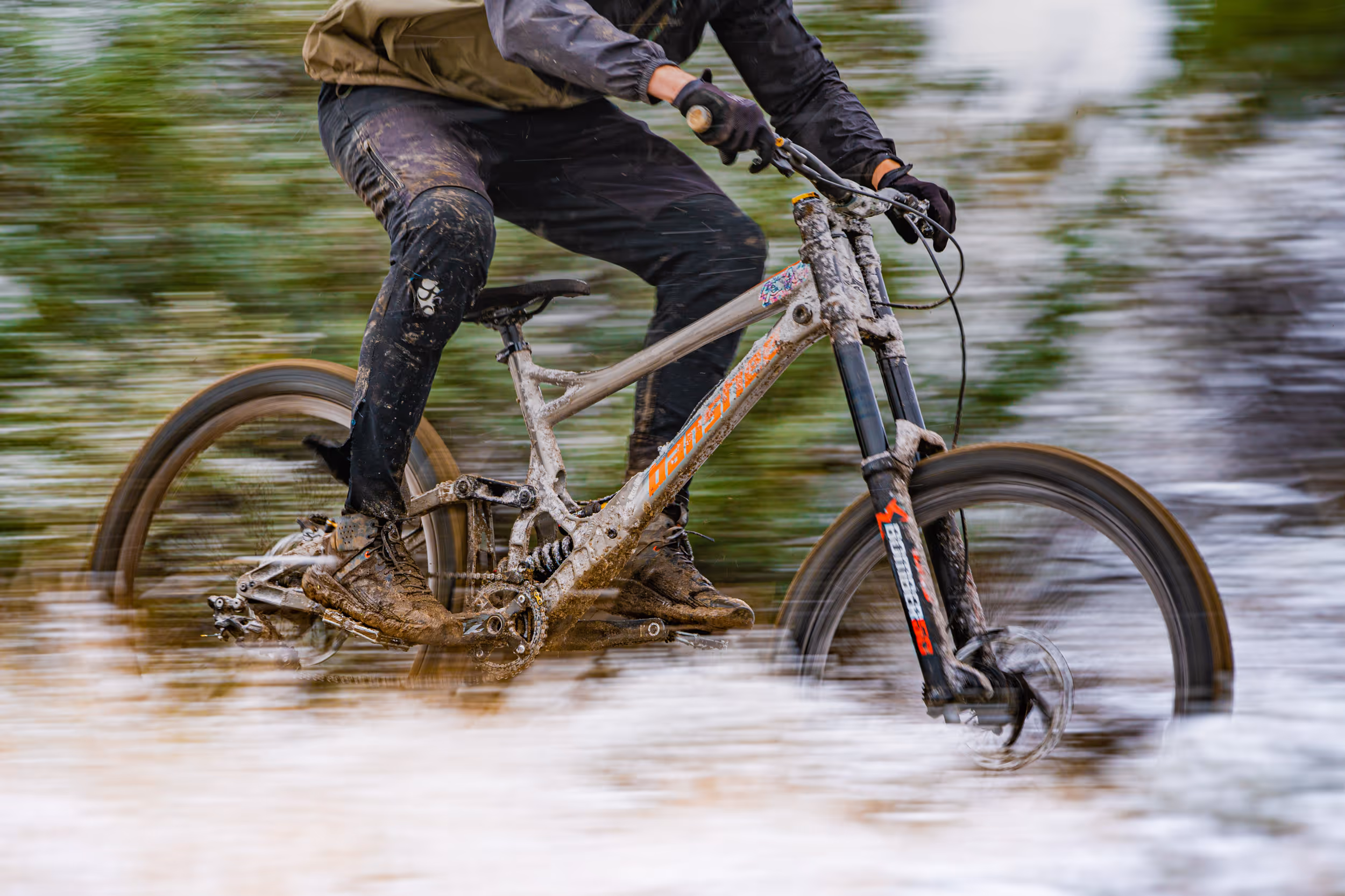 A mountain biker racing by the frost covered trail 