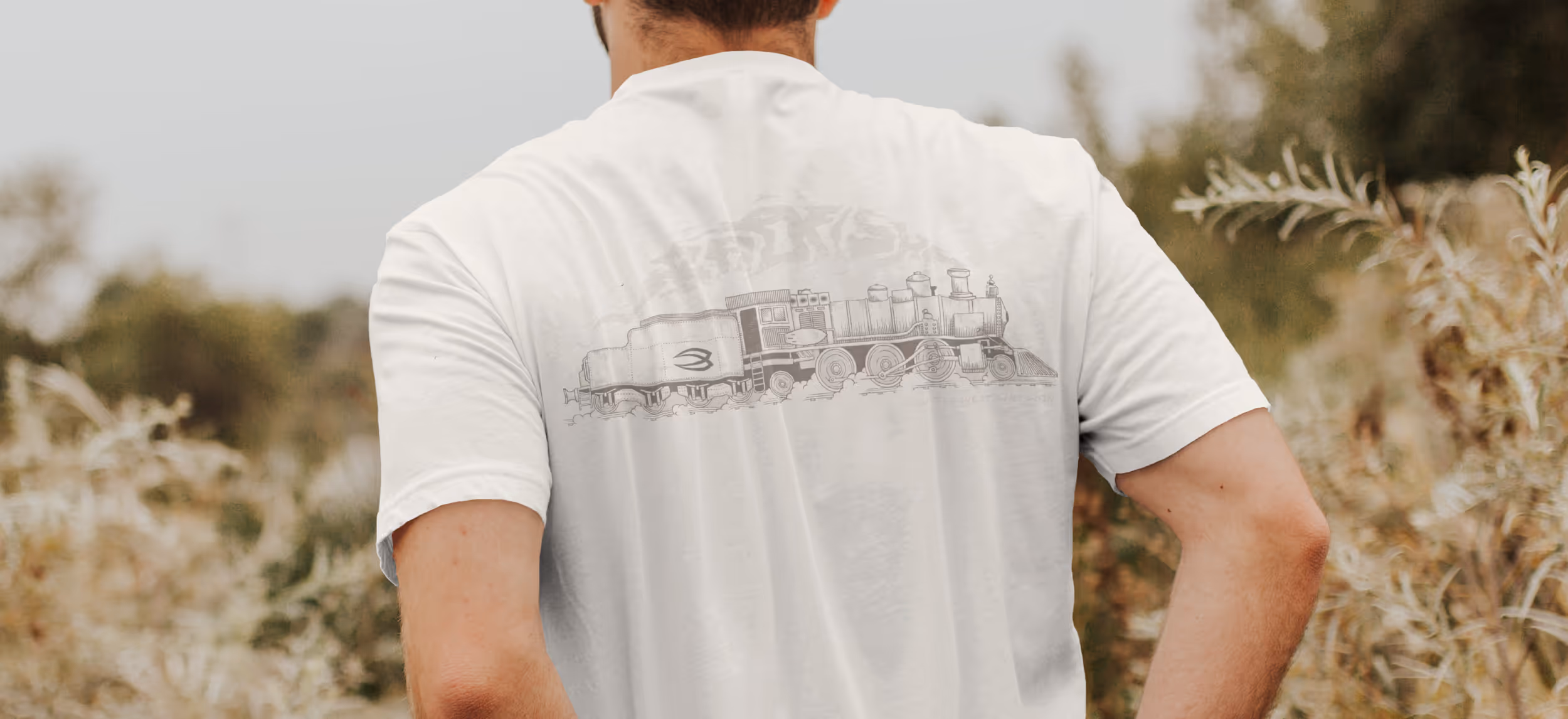 A man wearing a Badfish t-shirt with an old school train engine graphic 