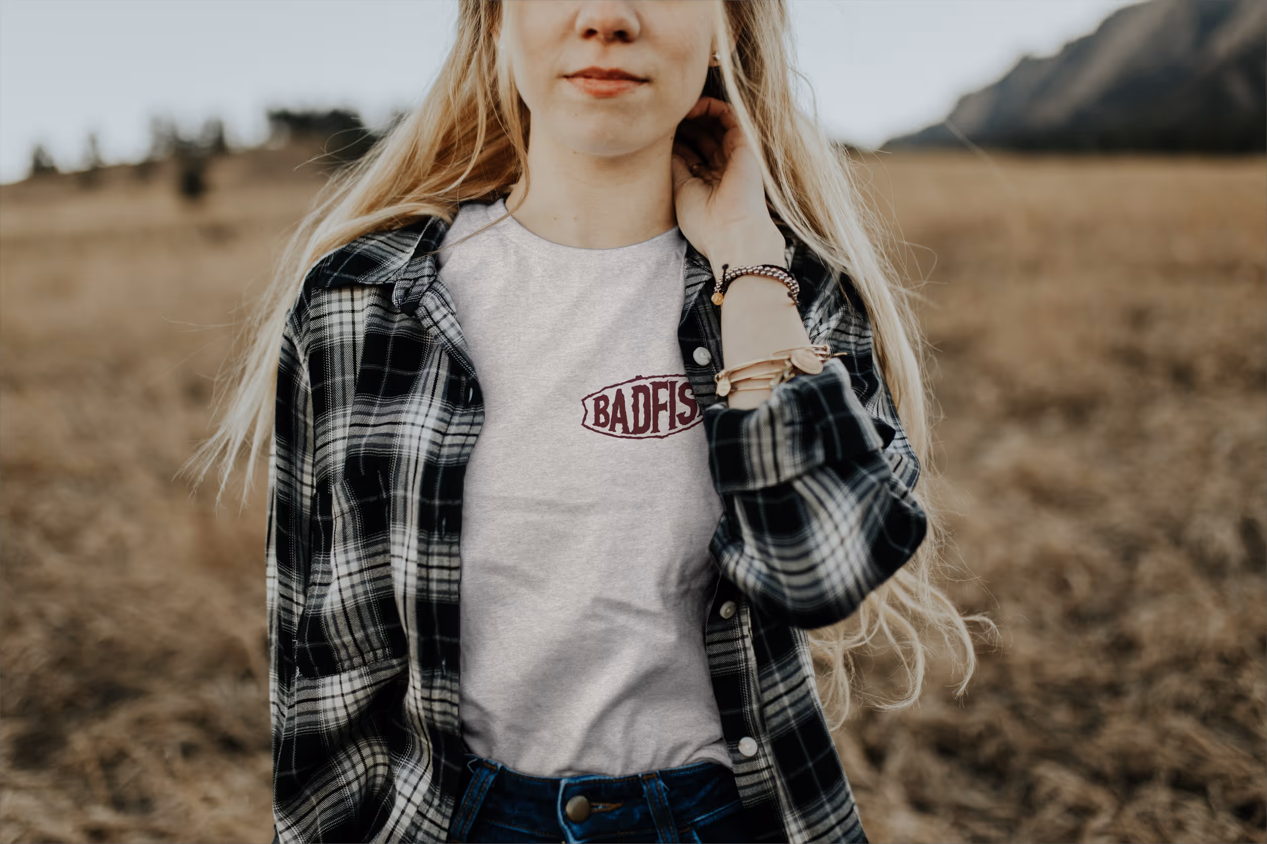 A woman wearing a white tshirt showing the Badfish logo on the front 