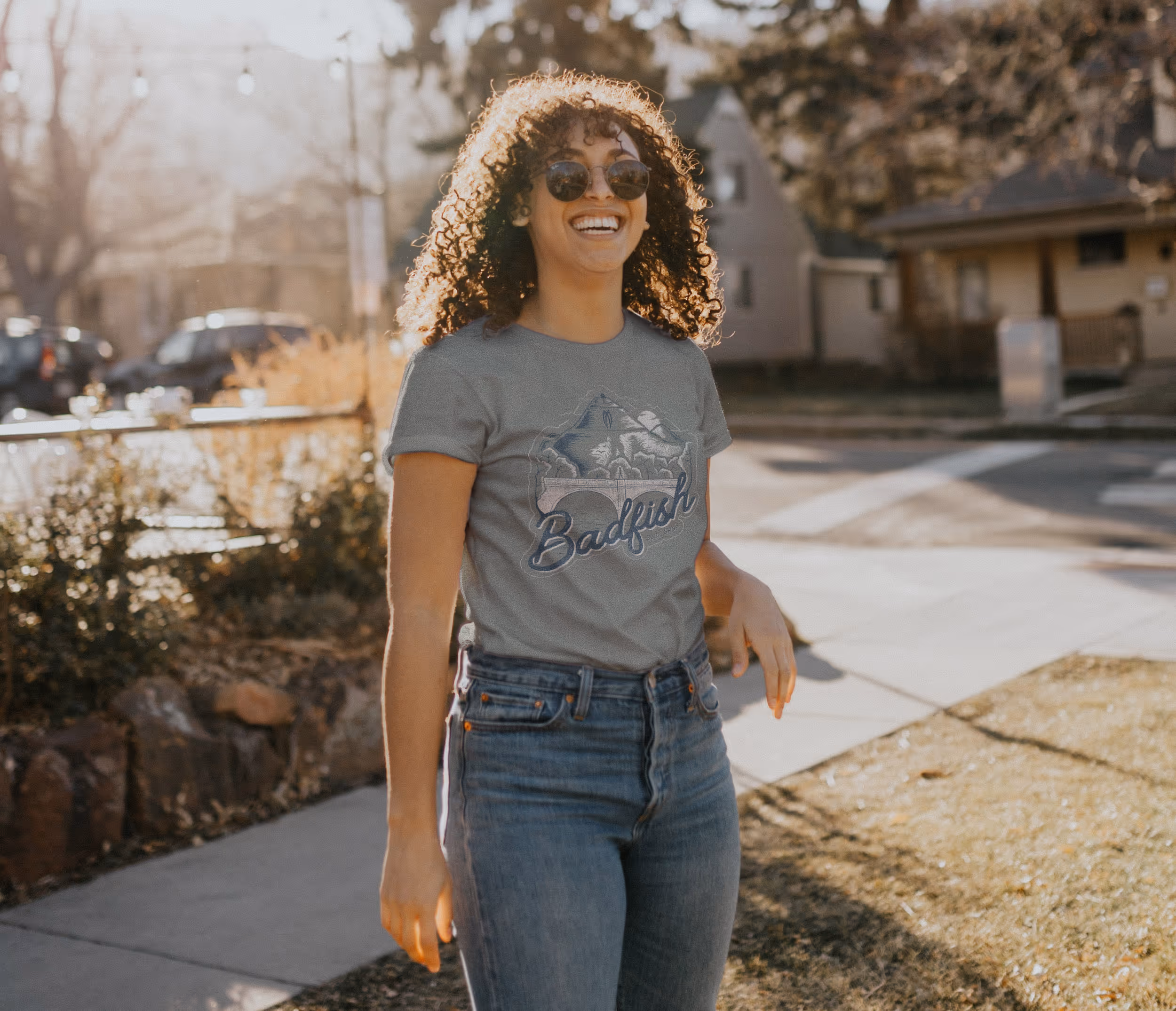 A woman wearing a badfish tshirt with the brand name, bridge, and mountain graphics 