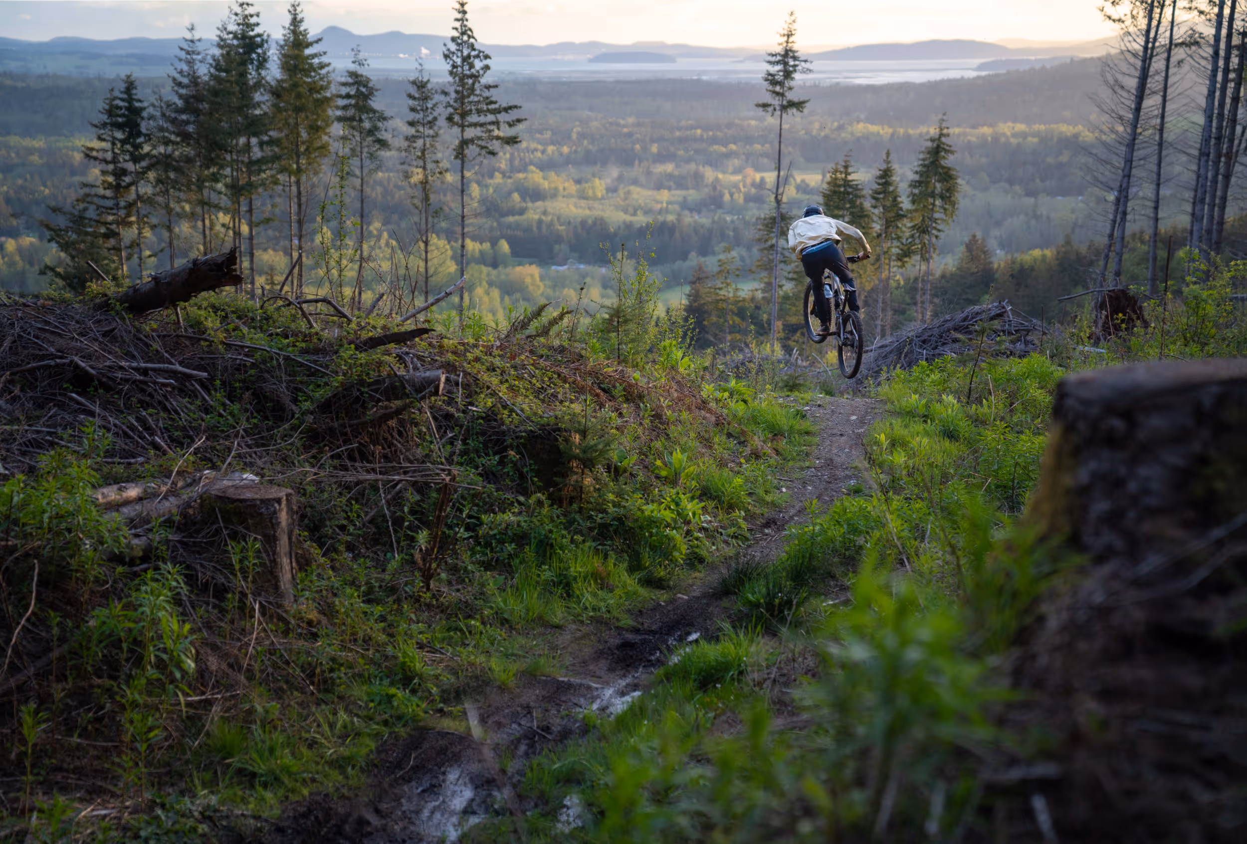 A mountain biker mid air as he preps to drop into a steep section of trail 