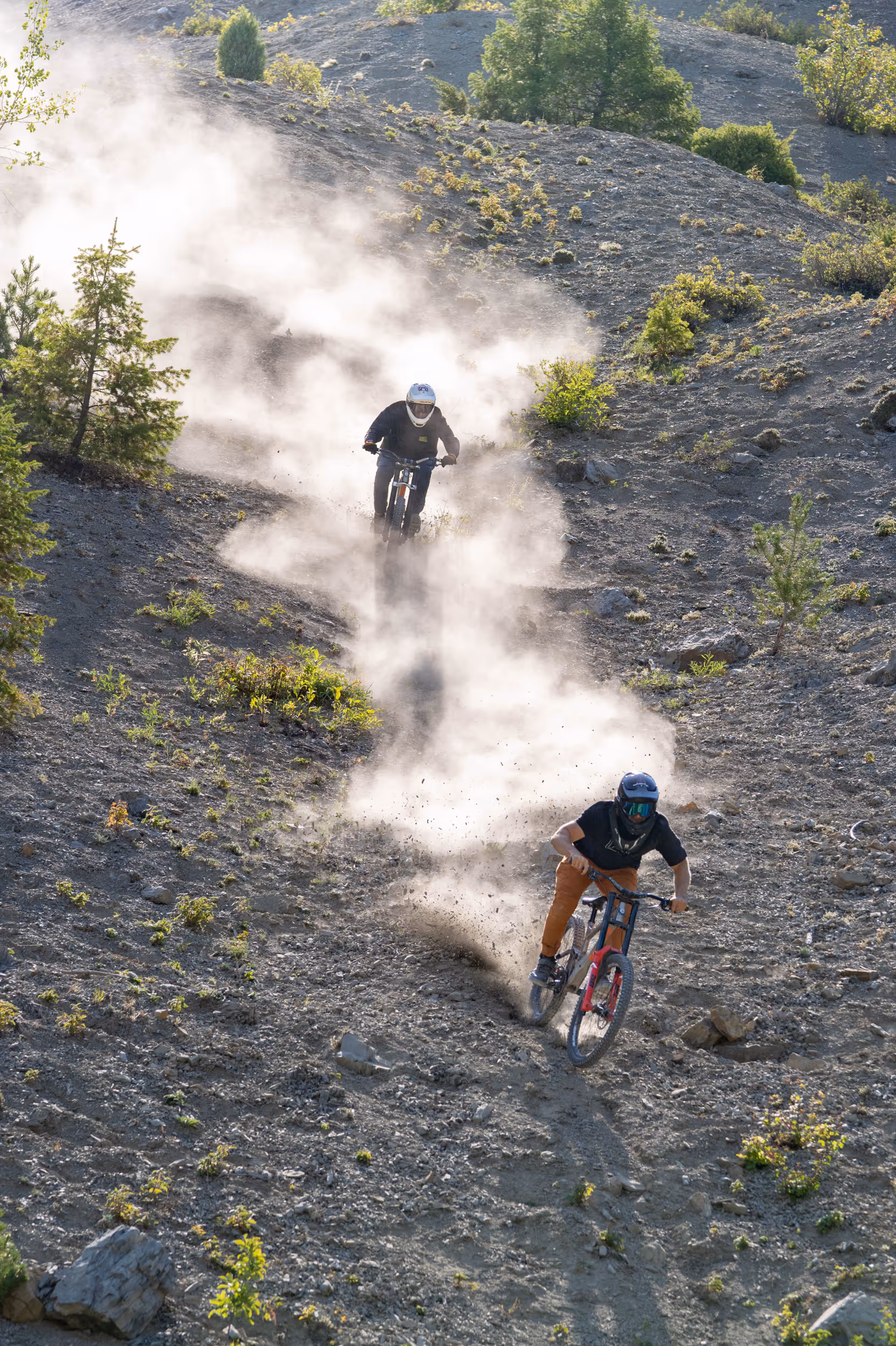Some mountain bikers navigating their way down a dusty trail