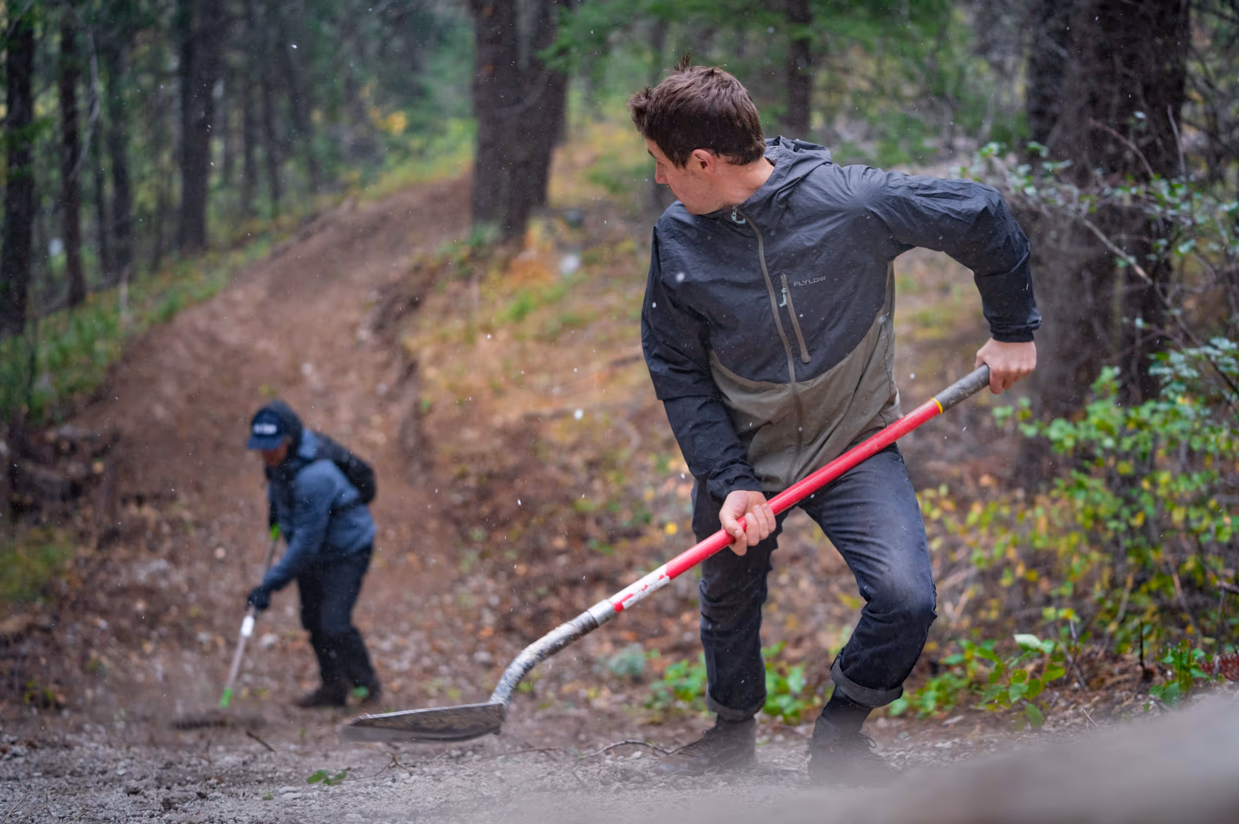 2 men performing some trail maintenance on a mountain bike trail