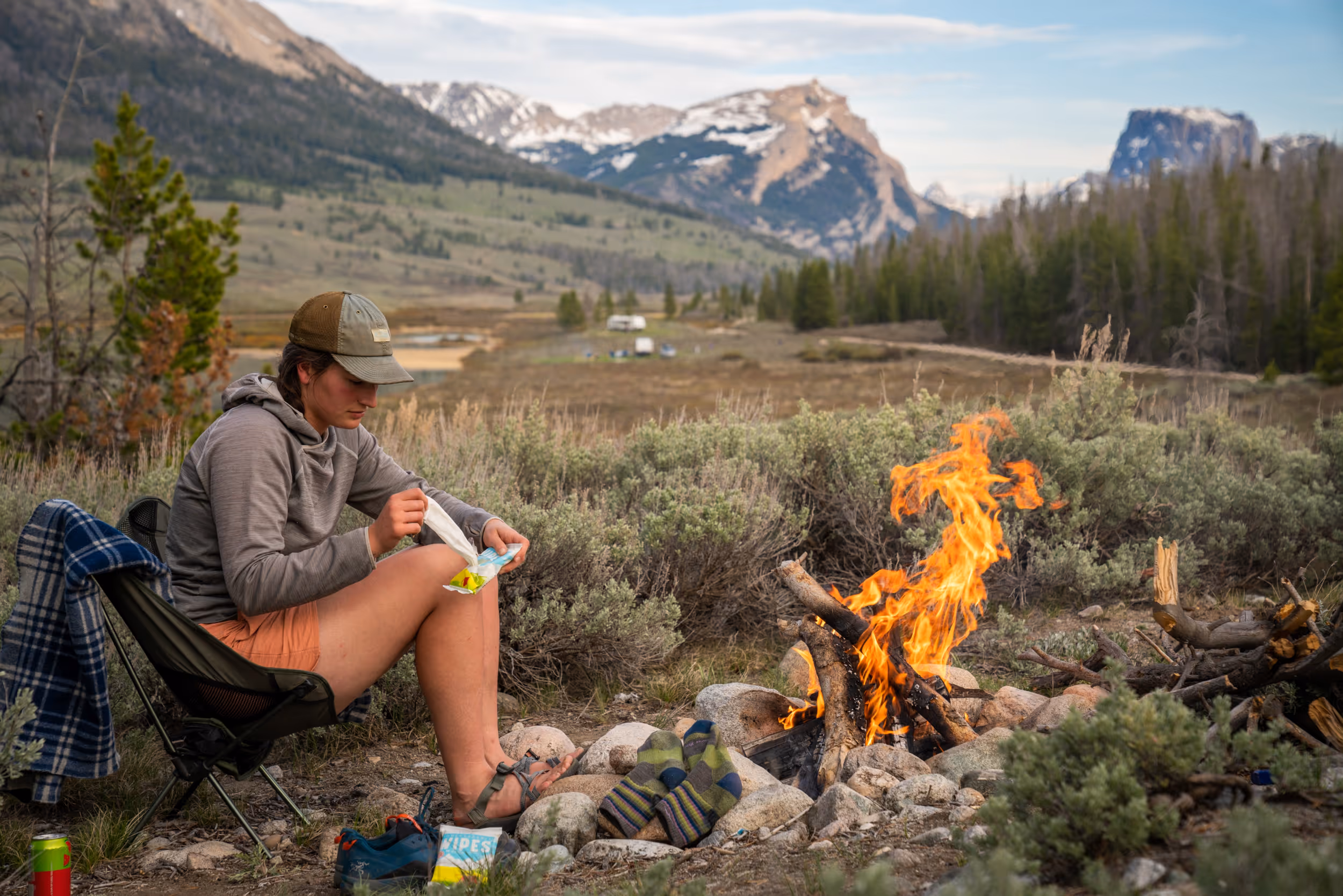 A camper using Bar-D body wipes around a campfire 
