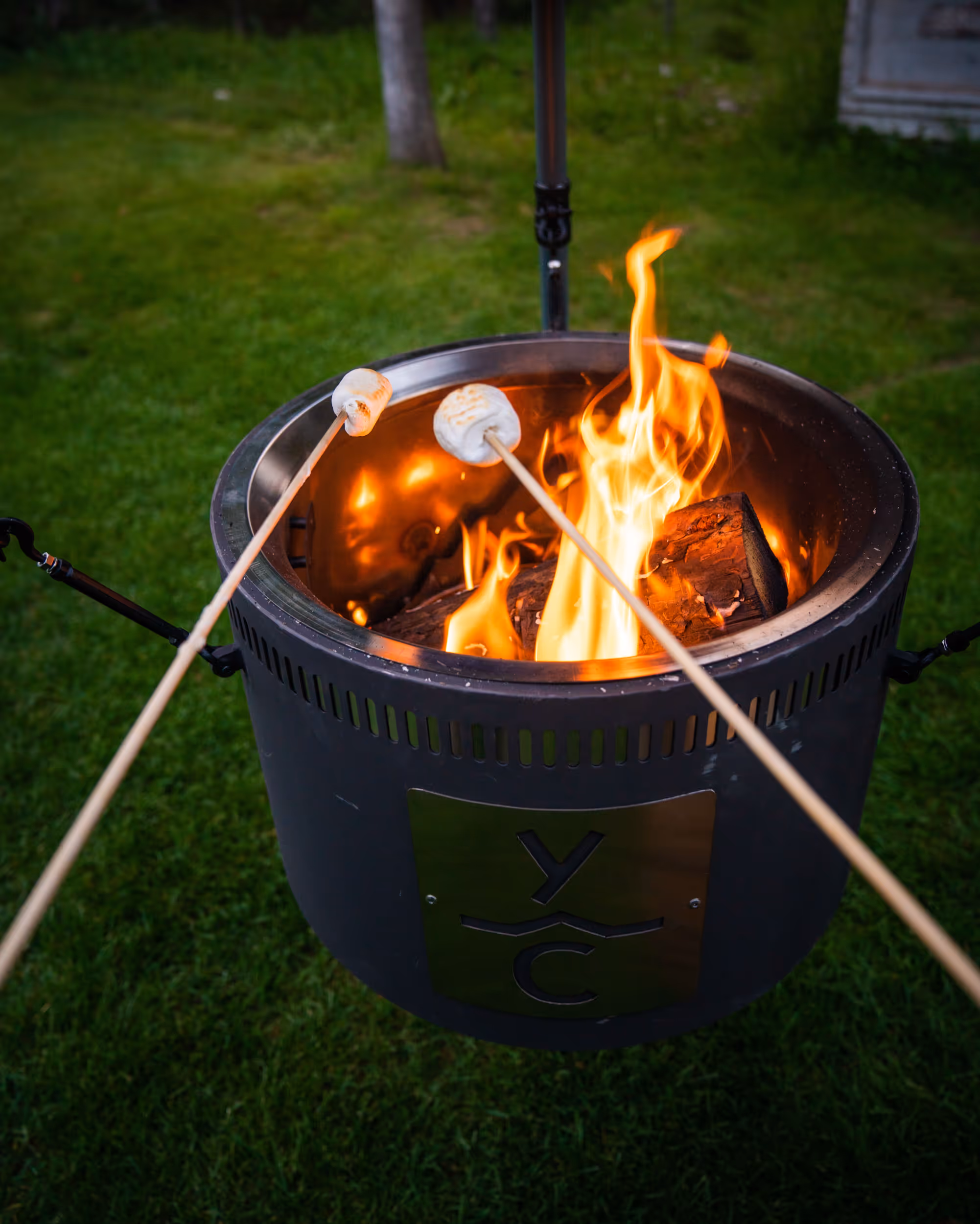 A POV of roasting marshmallows for smore's over an outside fire 