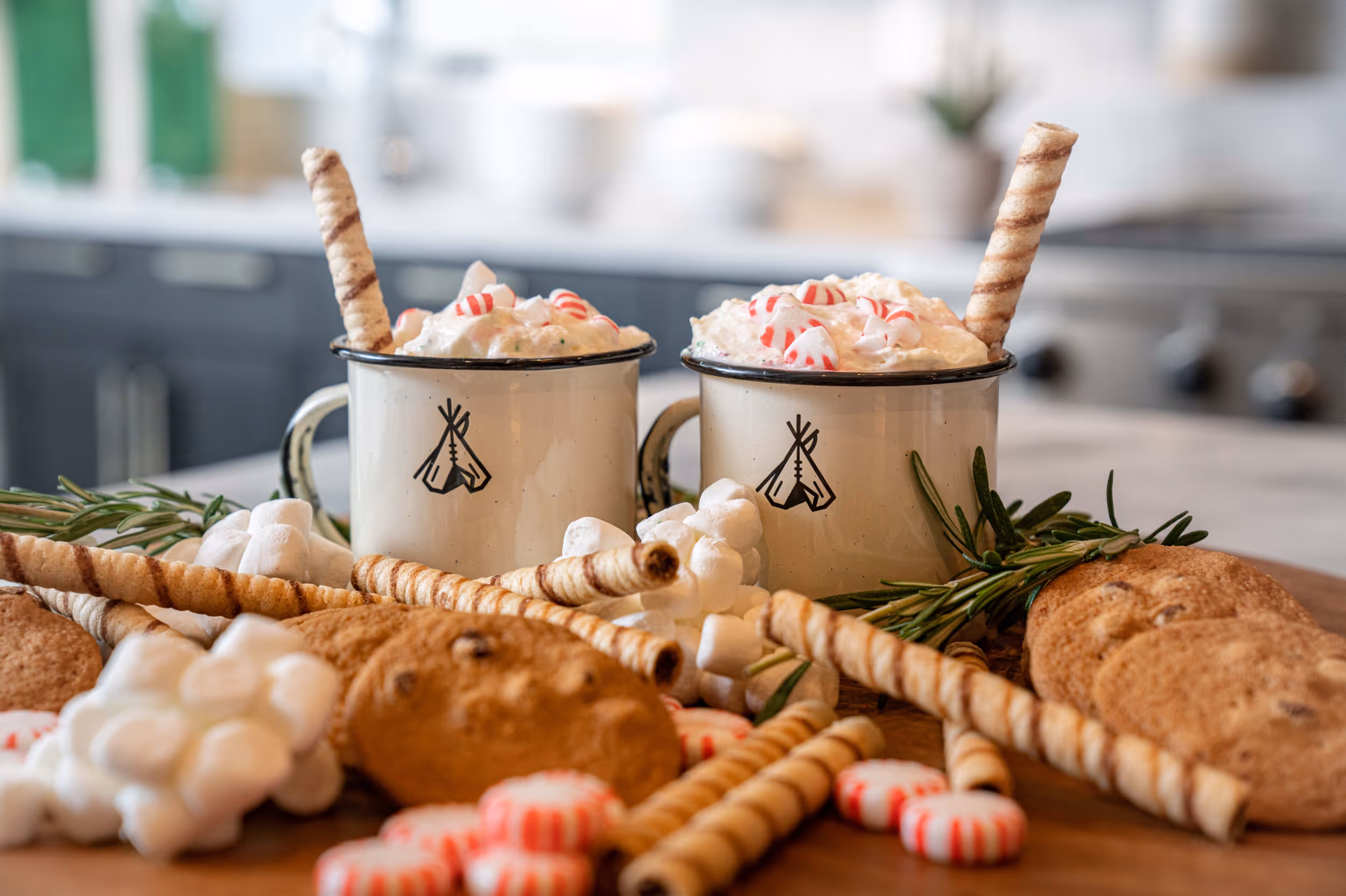 2 cups of fancy hot chocolate topped with whipped cream and crushed mint candies on top 