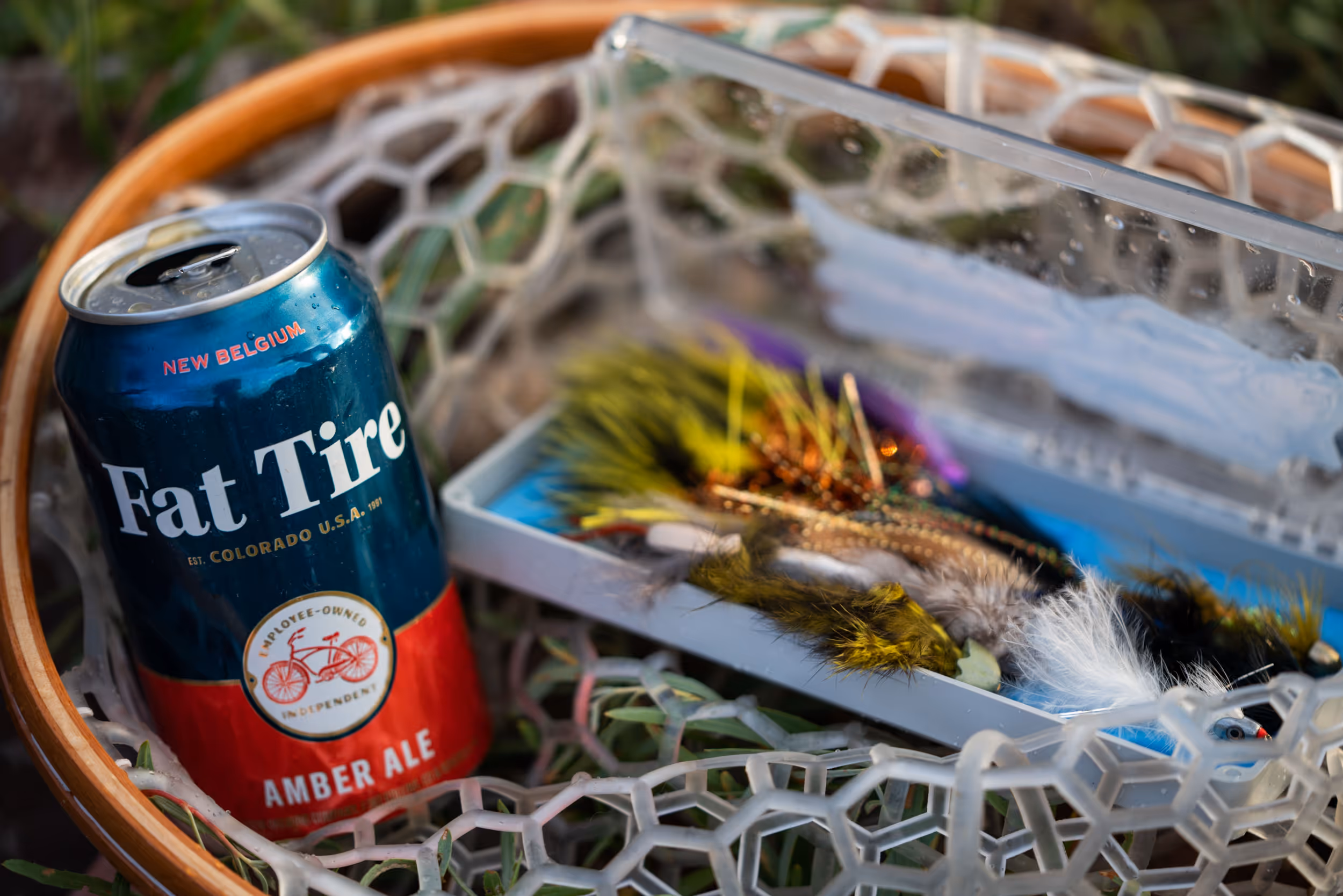 A fishing net holding a cold Fat Tire beer and some yummy snacks 