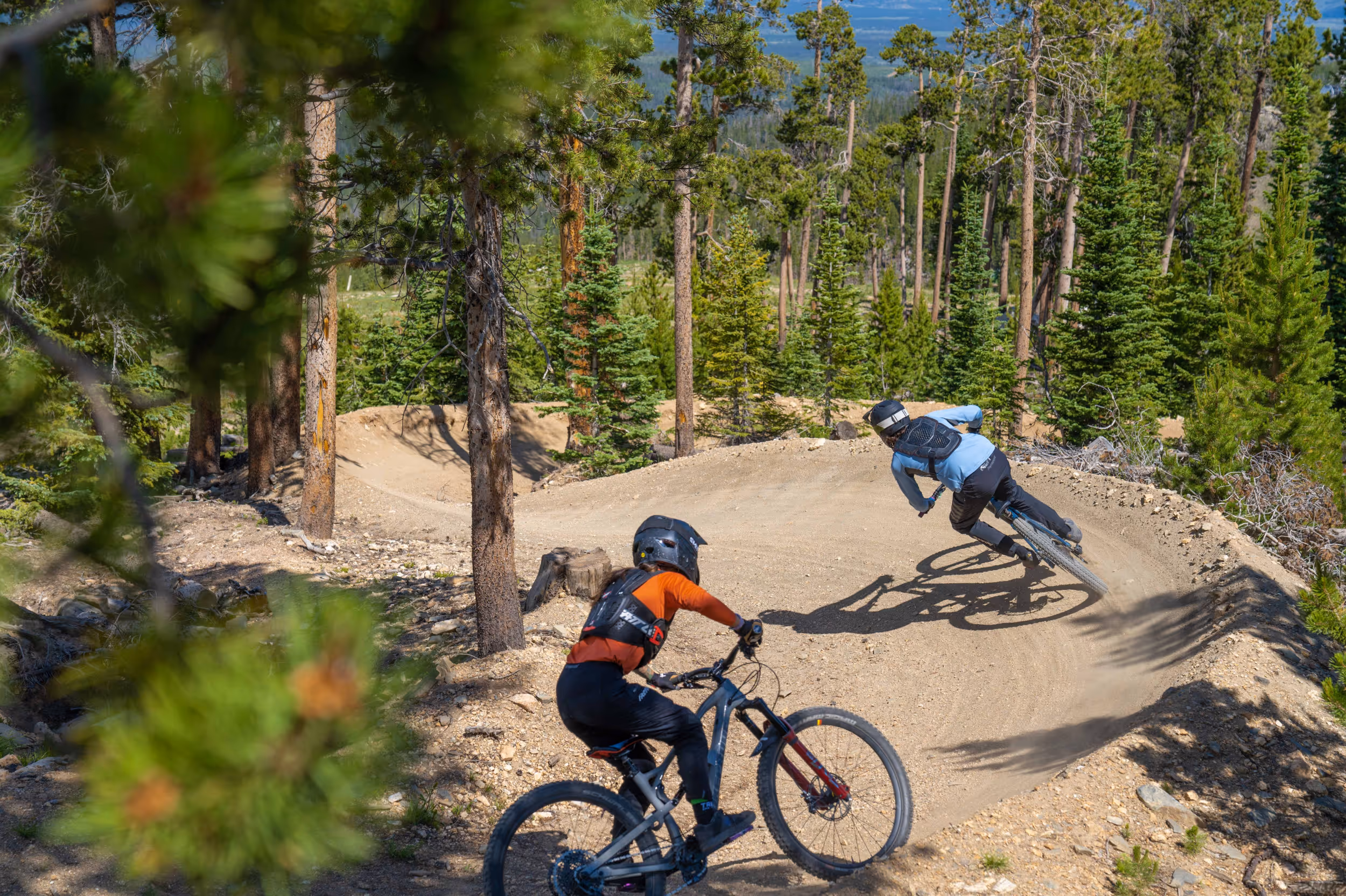 2 mountain bikers hitting a berm on a twisty section of trail 