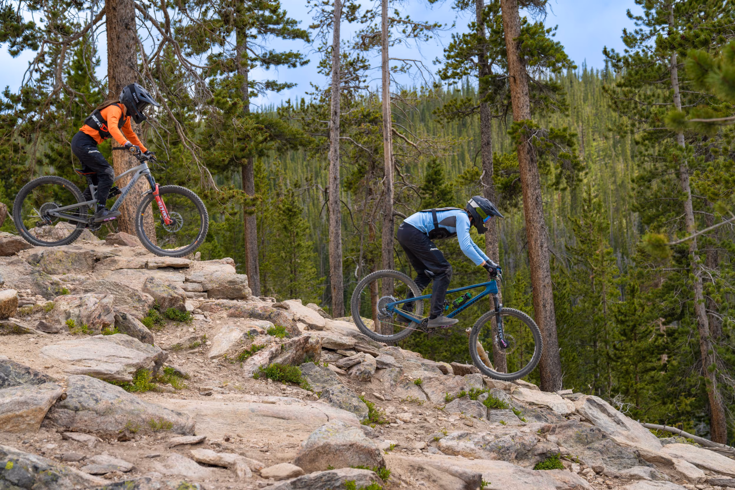 2 mountain bikers navigating a technical rocky section of trail 