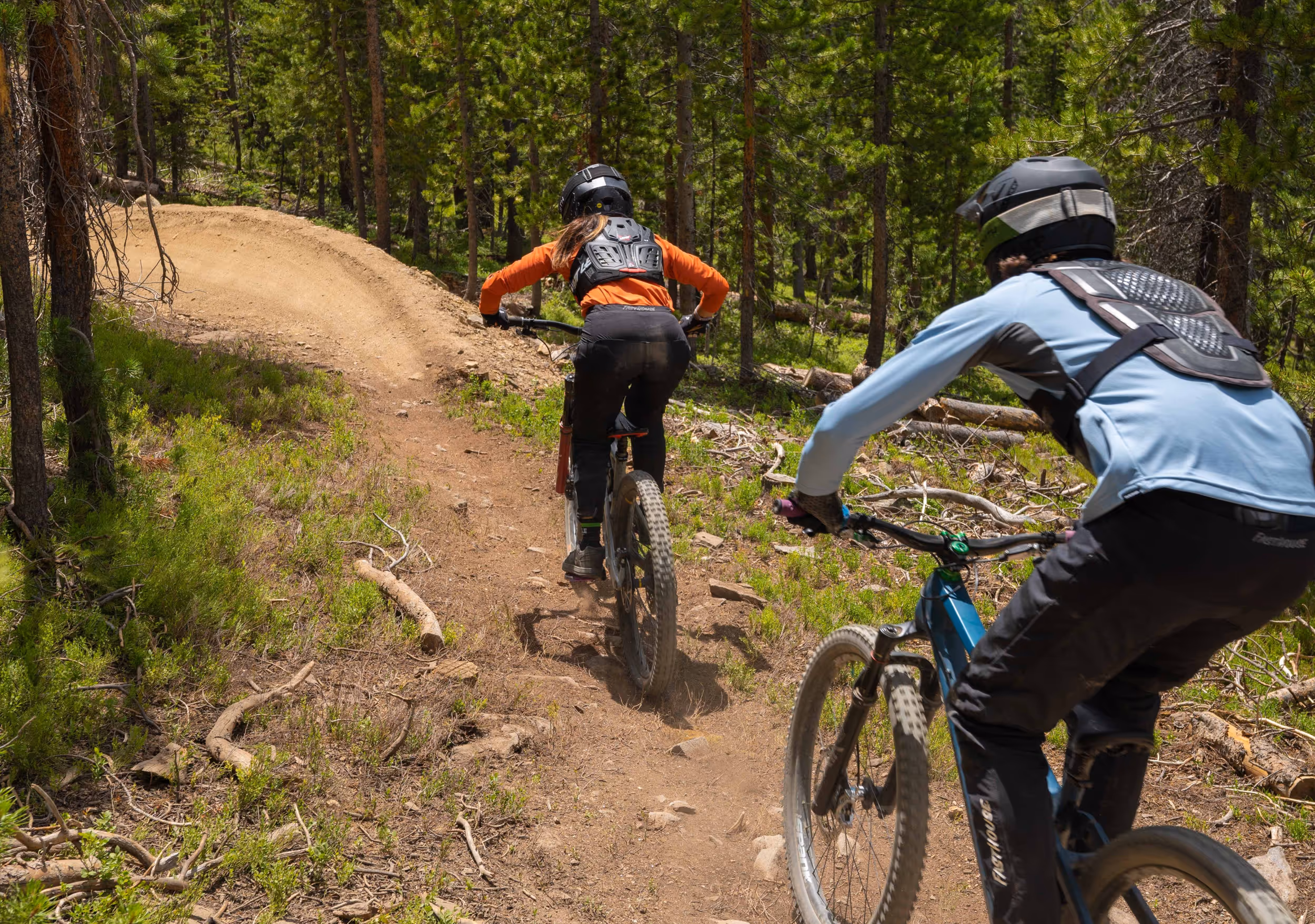 2 mountain bikers dropping into a berm 