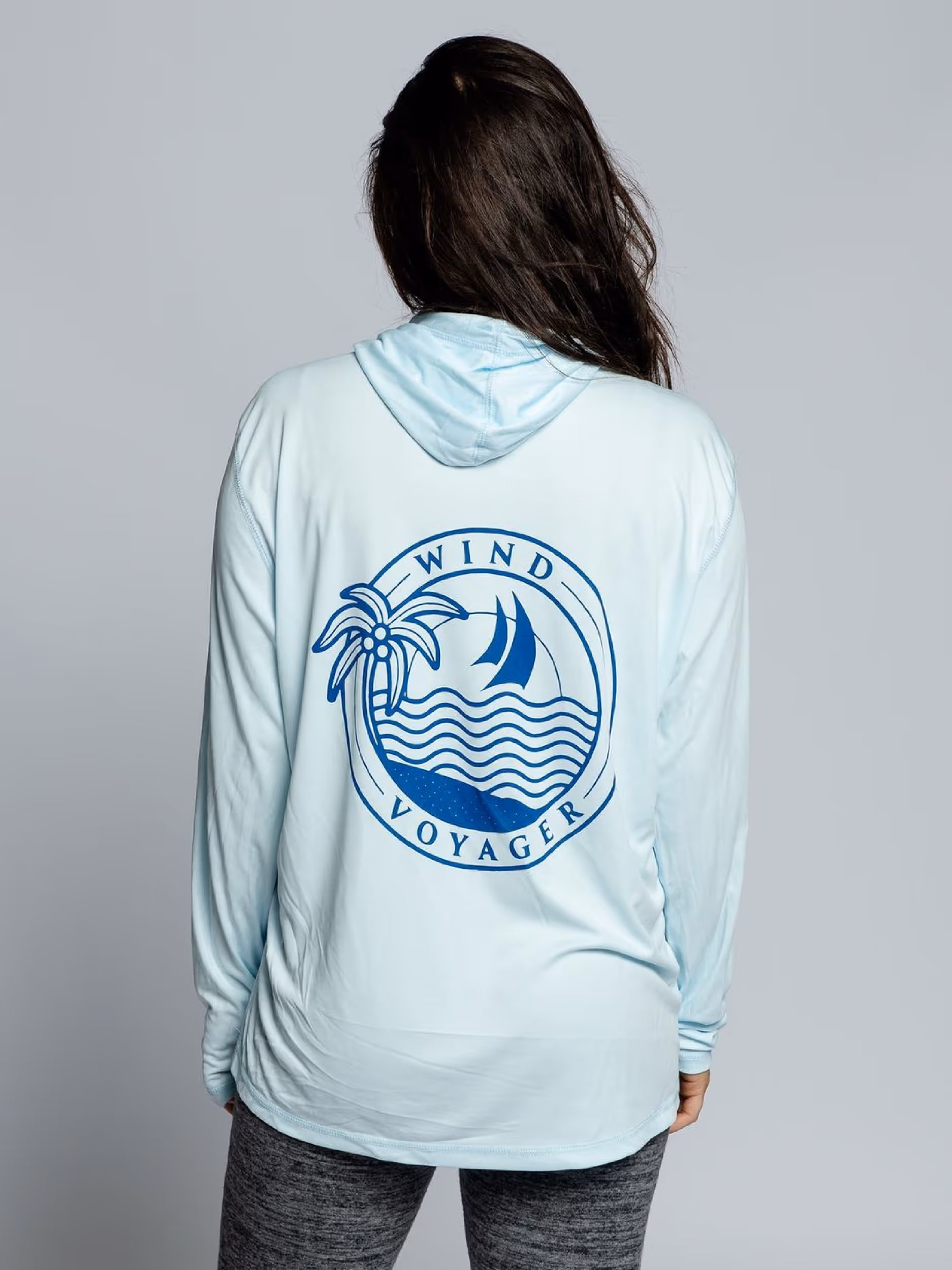 Woman wearing white Wind Voyage sun hoody 