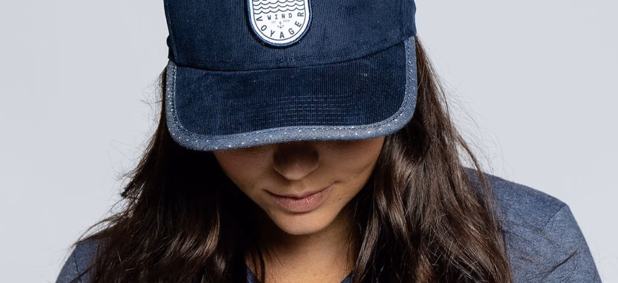 Hero image of a woman wearing a blue corduroy Wind Voyager hat
