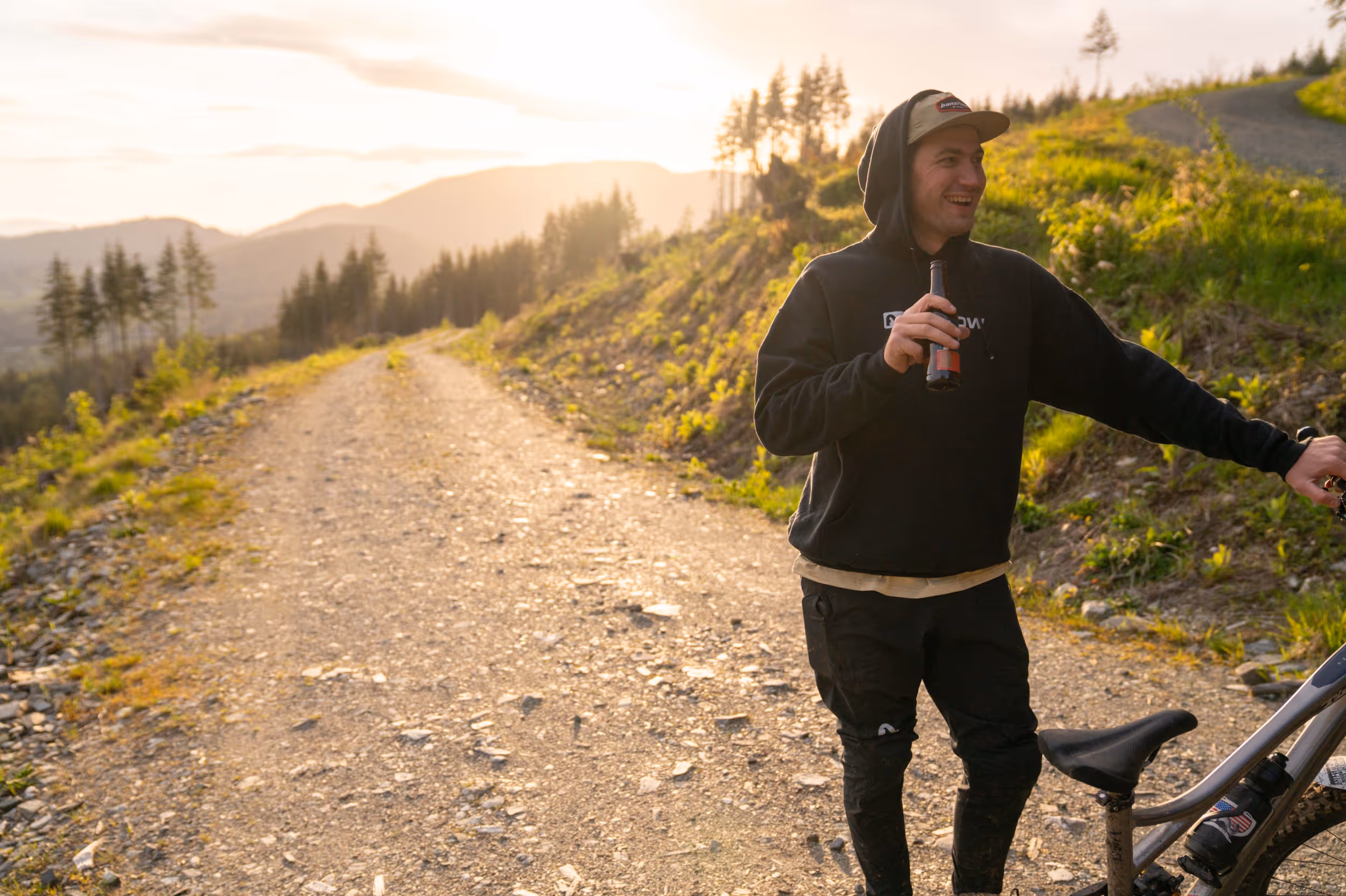A mountain biker enjoying a FatTire beer after a ride during golden hour 