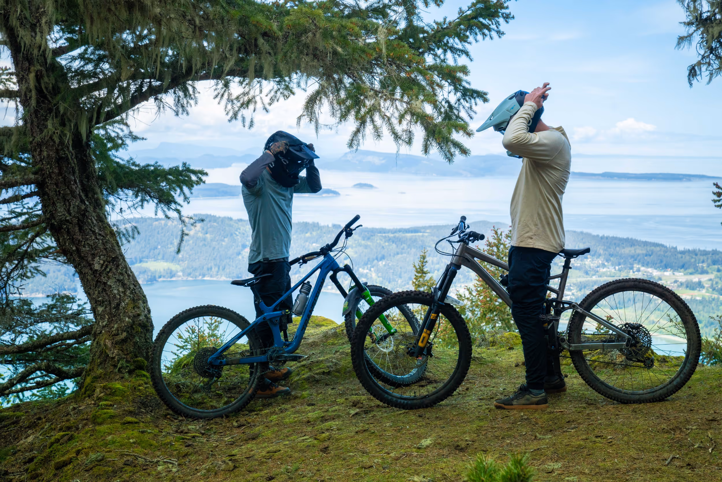 Some mountain bikers removing their helmets to take a breather mid ride 