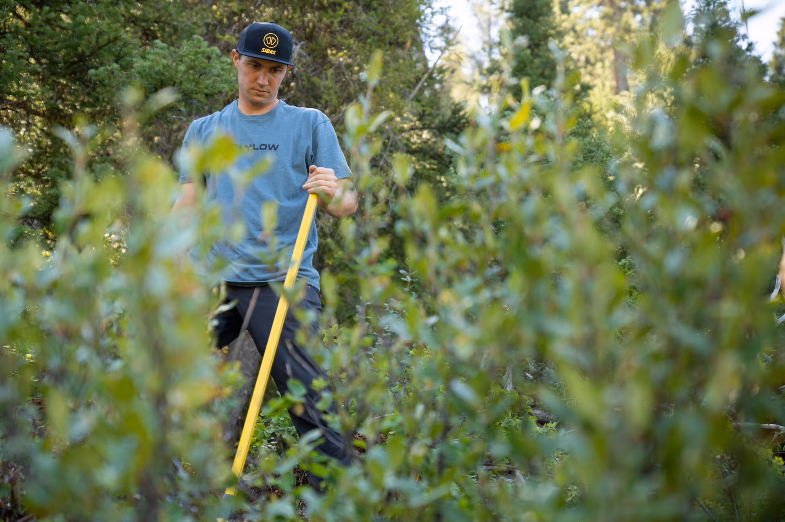 A man admiring his work after doing some trail maintenance on a mountain bike ride 