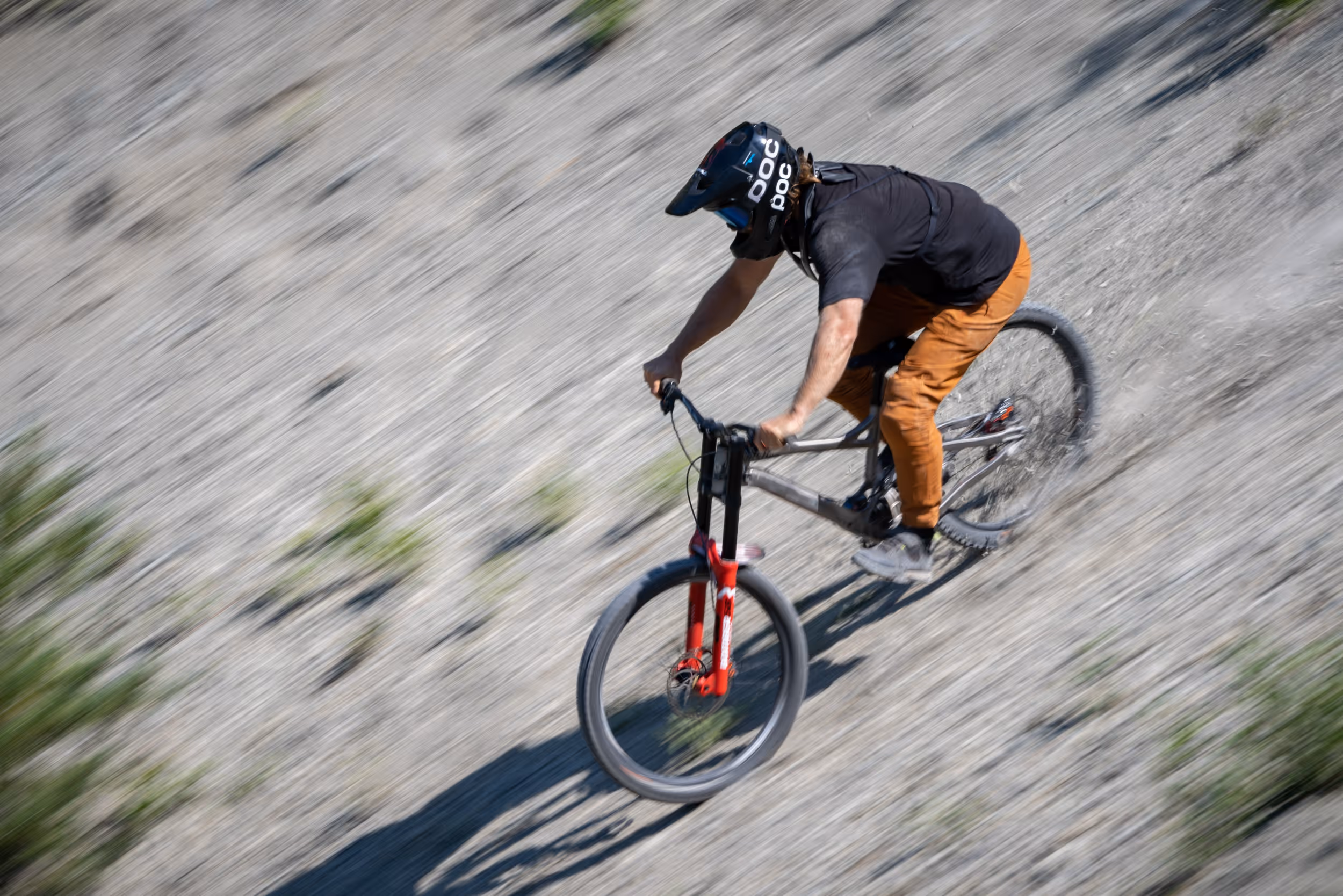 A mountain biker navigating down a dusty ridge 