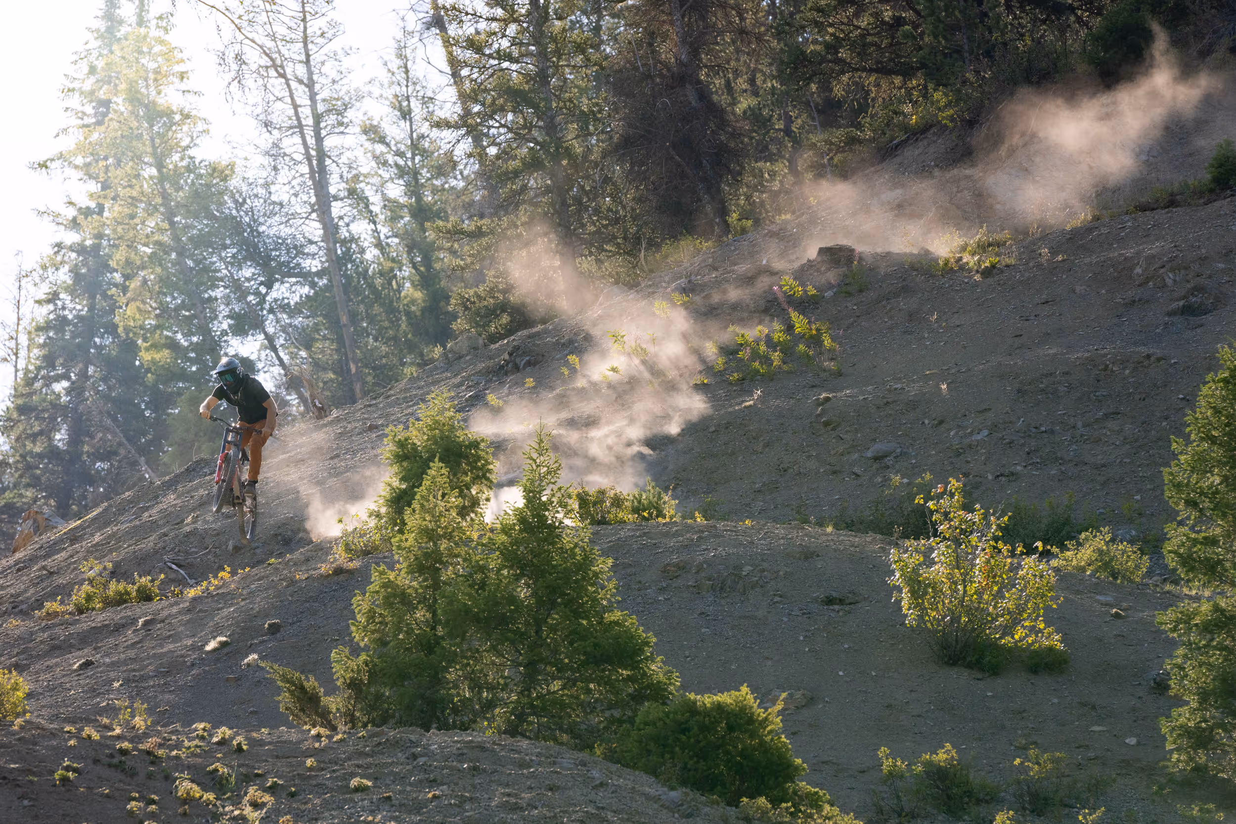 A mountain biker getting some sick air while riding down a steep trail 