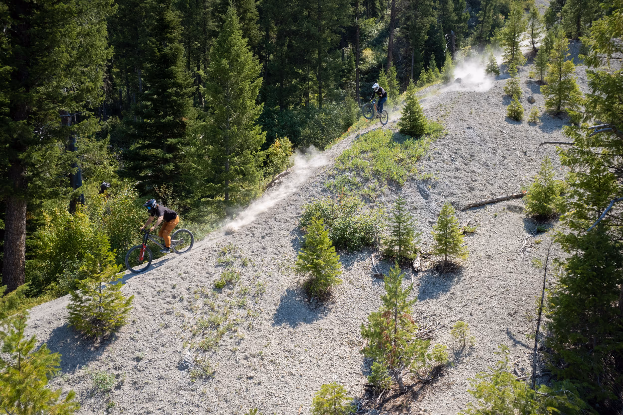 A mountain biker navigating their way down a steep dusty hill