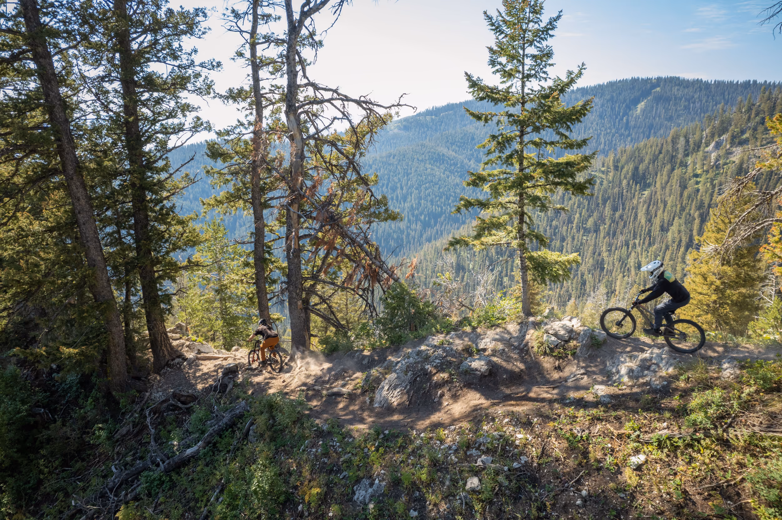 A mountain biker navigating their way through a rocky section of ridge trail