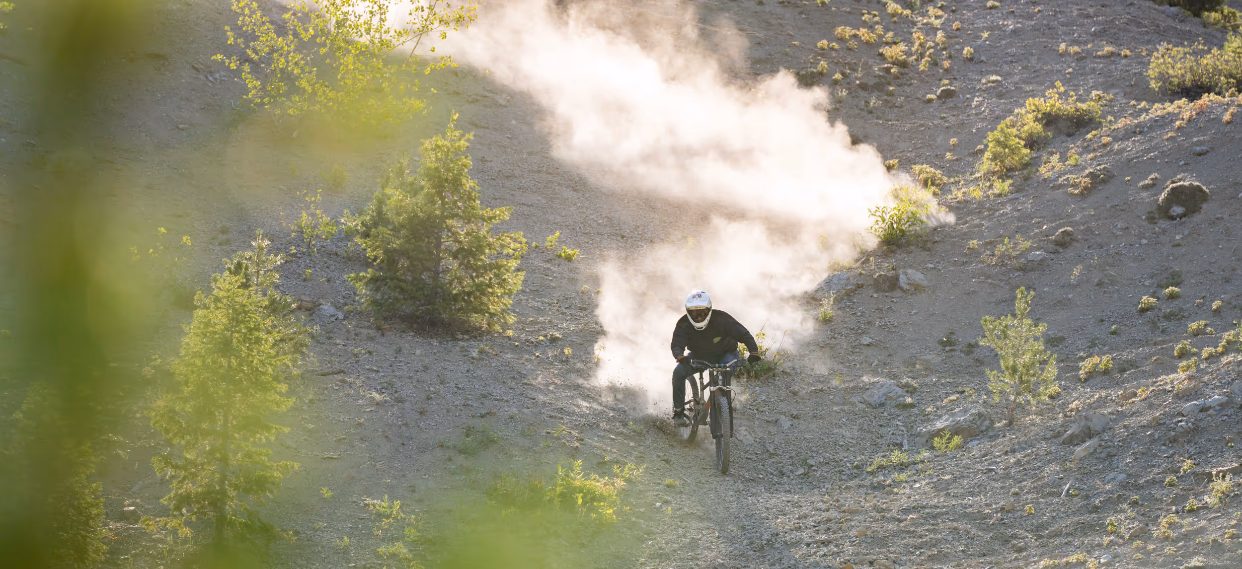 A mountain biker coming down a dusty trail
