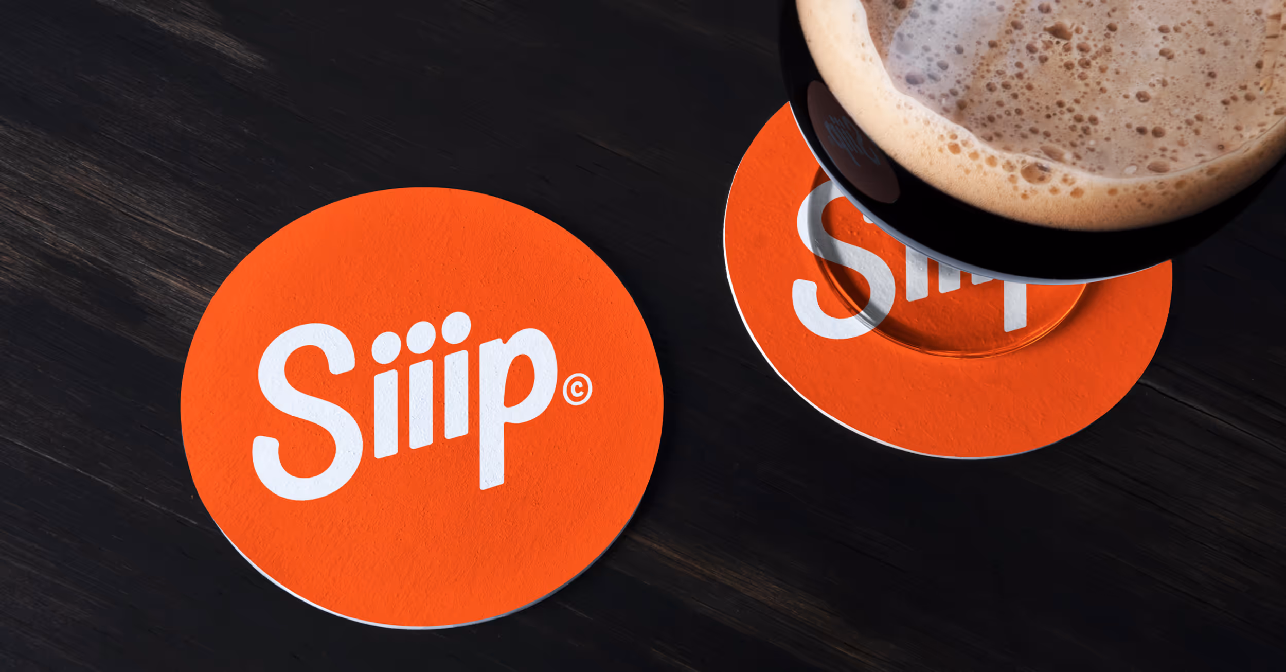 Siiip drink coasters with a frothy beer sitting on one 