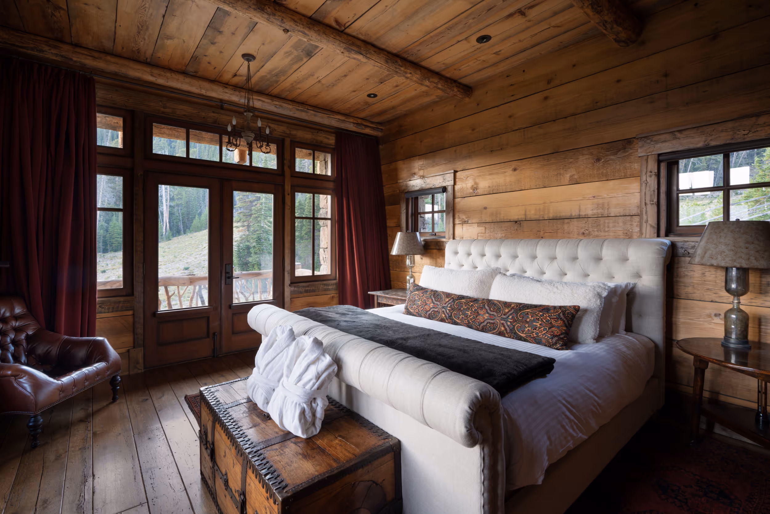 A large wooden interior luxury bedroom with a lovely plush bed in the middle 