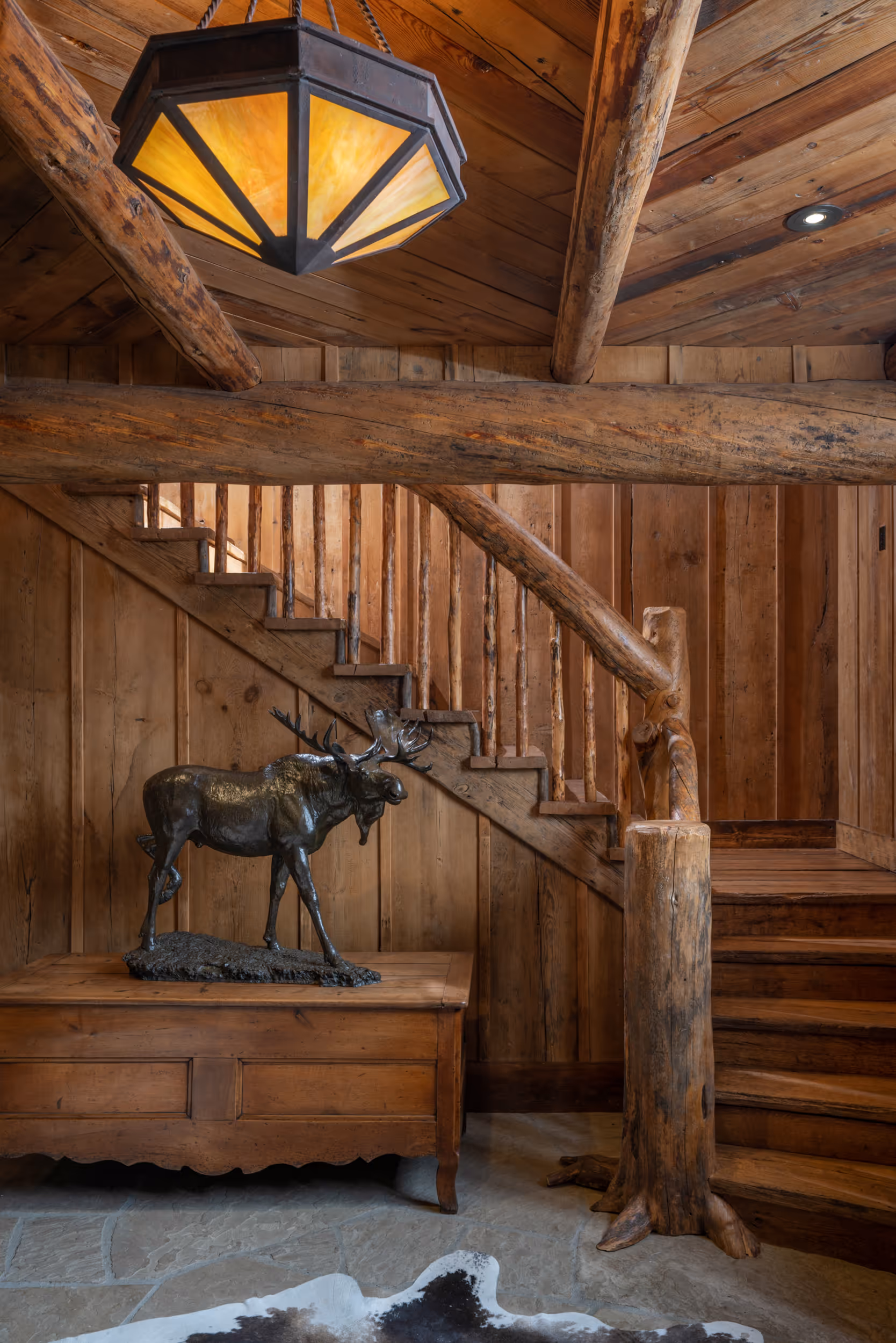 An interior staircase of a luxury cabin with with a modern, rustic wooden cabin aesthetic 