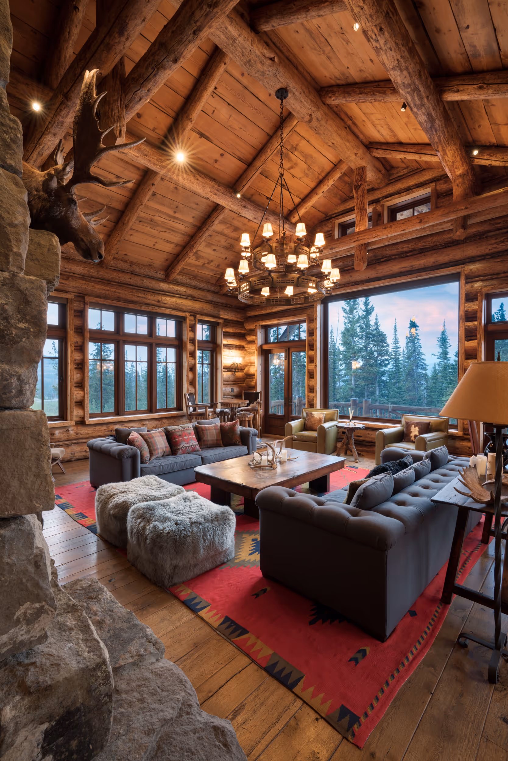 An overview of a spacious living area in a luxury log cabin showing large windows