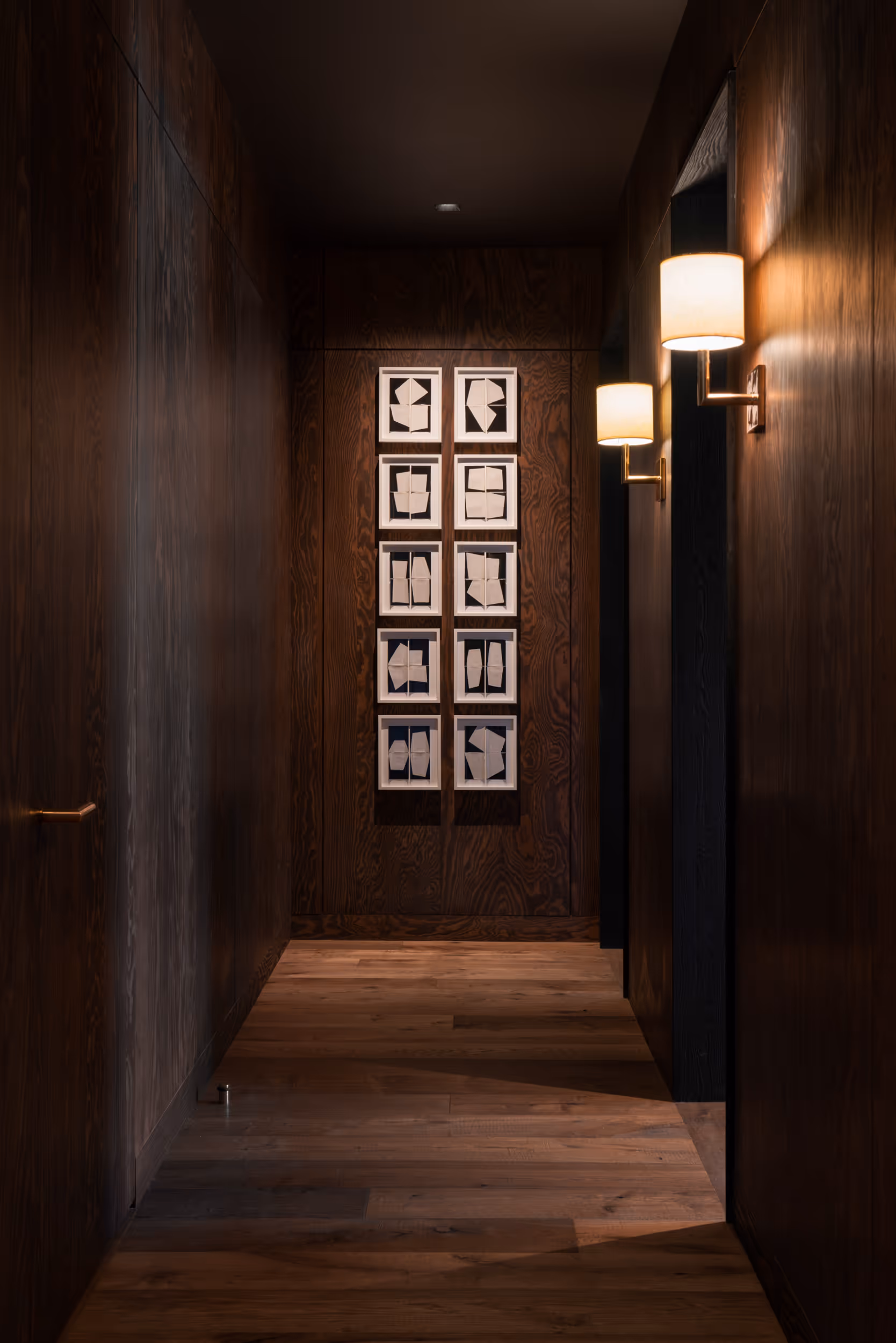 A modern, dark wood hallway with some well placed modern art 