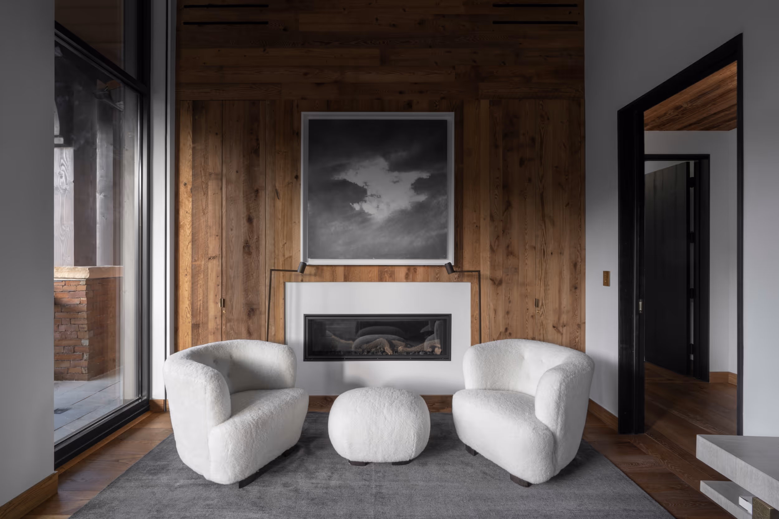 A luxurious sitting area with 2 cozy chairs in front of a fire place 