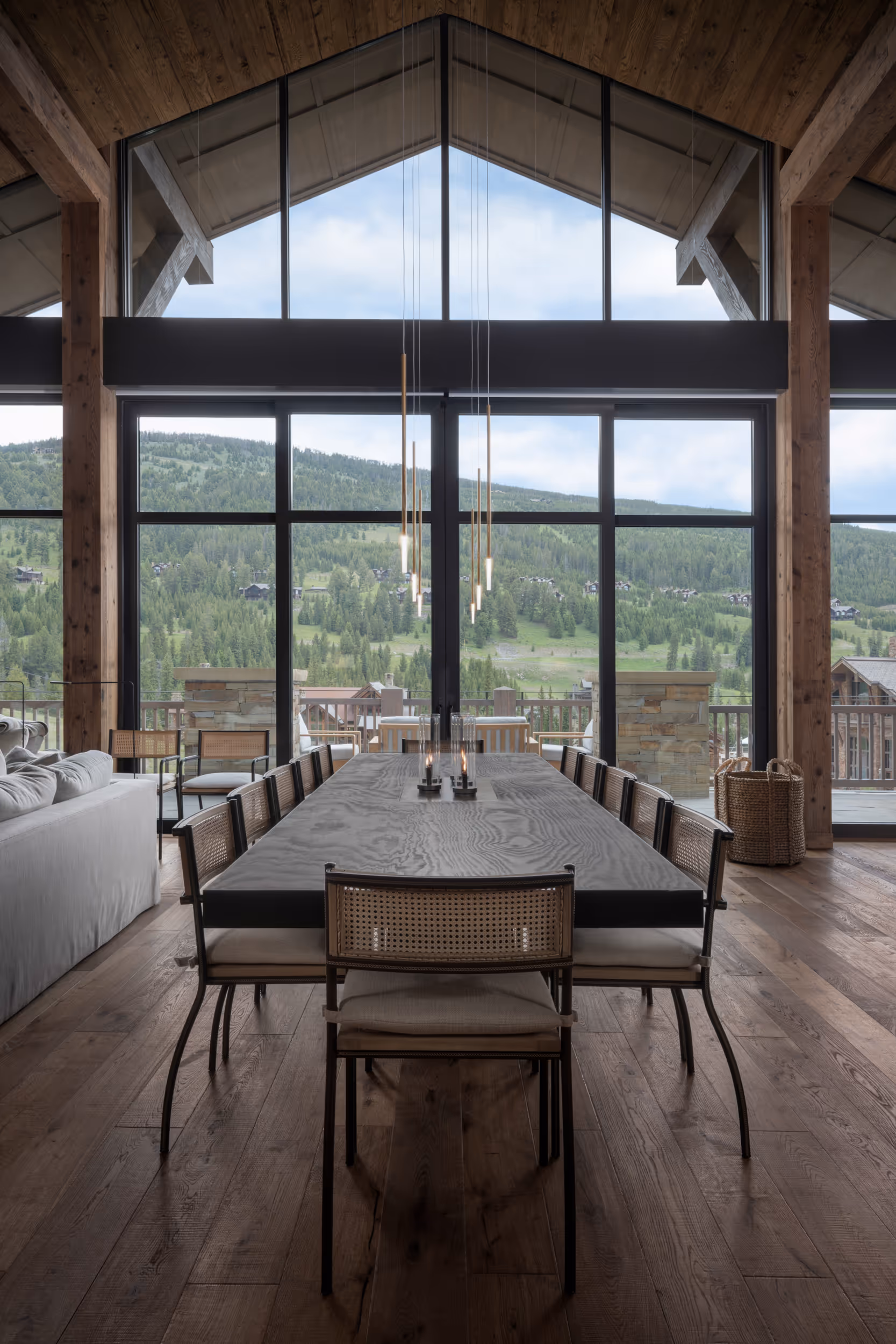 A luxurious modern dining area looking longways across the table to the huge windows