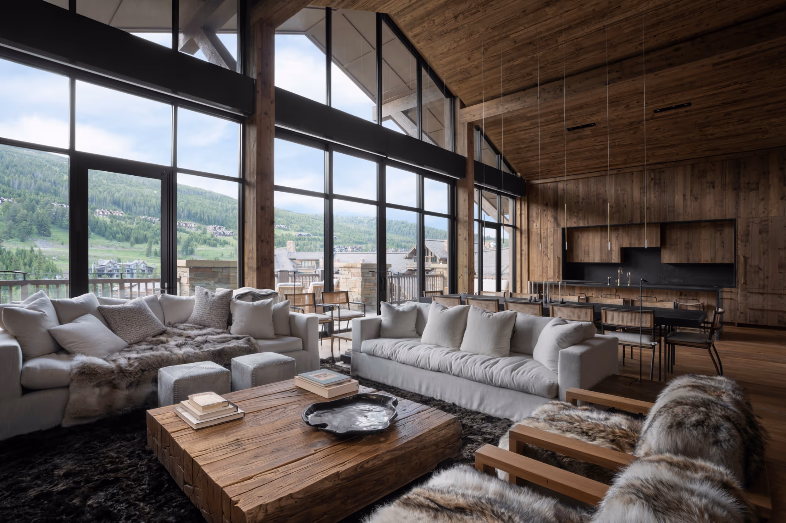 A large luxurious living area with large windows and dark wood interior 