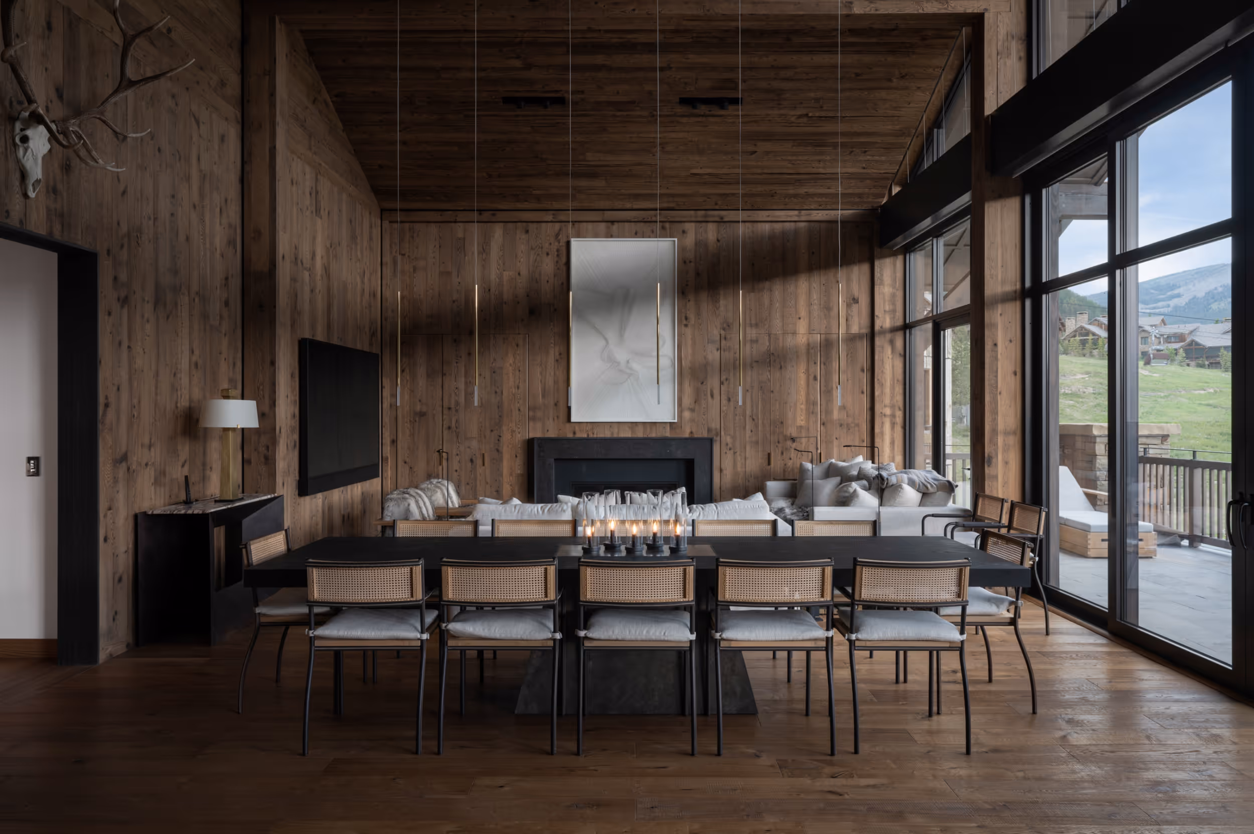 A luxurious modern dining area with large windows and a dark wooden interior 