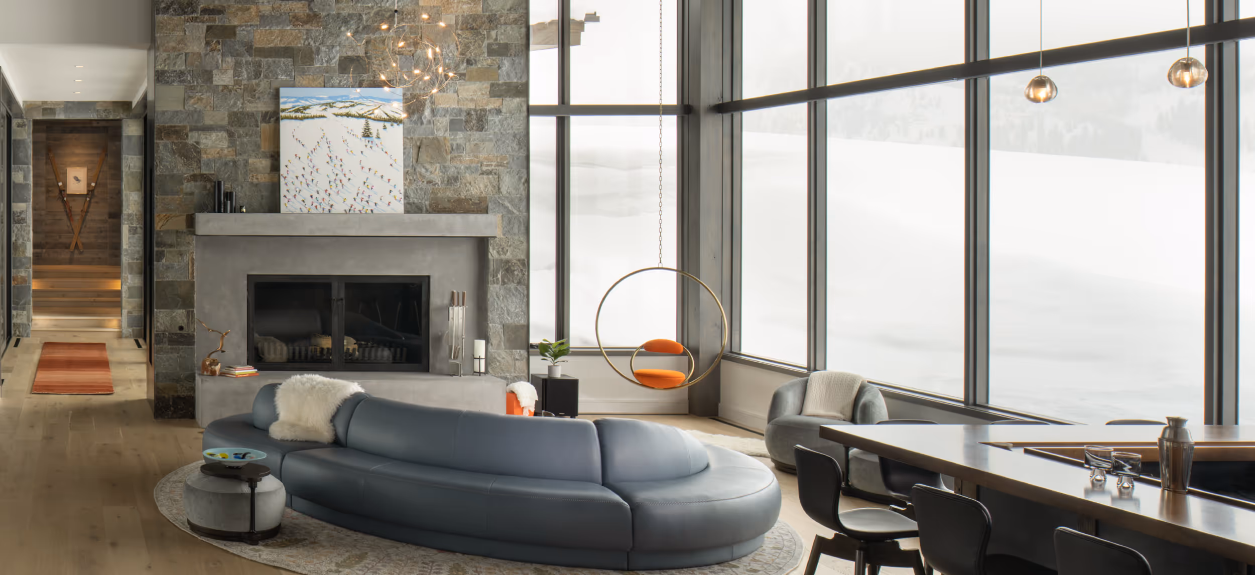 A luxurious, modern living area with a bar, a sleek couch, and a geometric chair hanging from the ceiling 