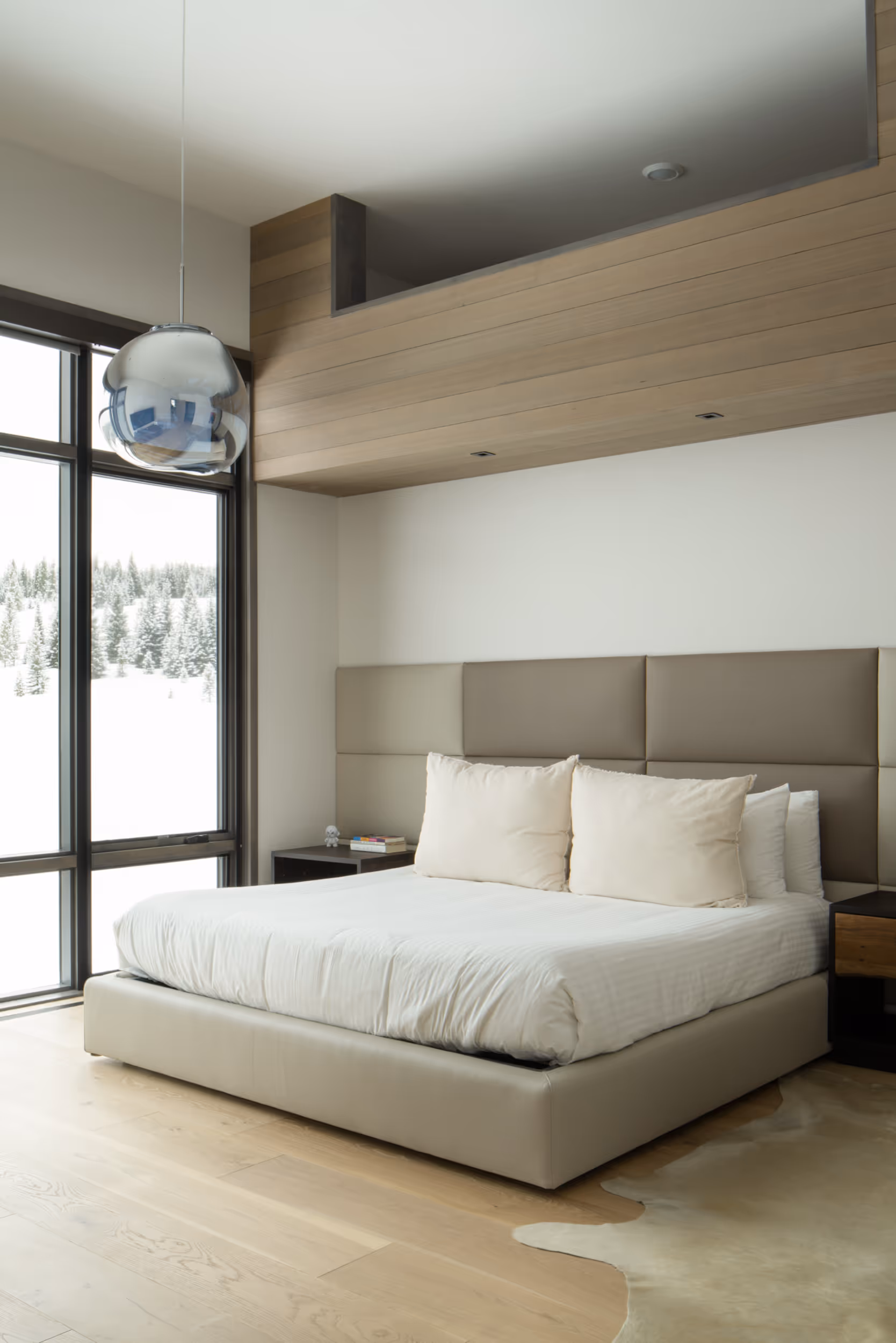 A luxurious bedroom with 1 wall that's all glass window 