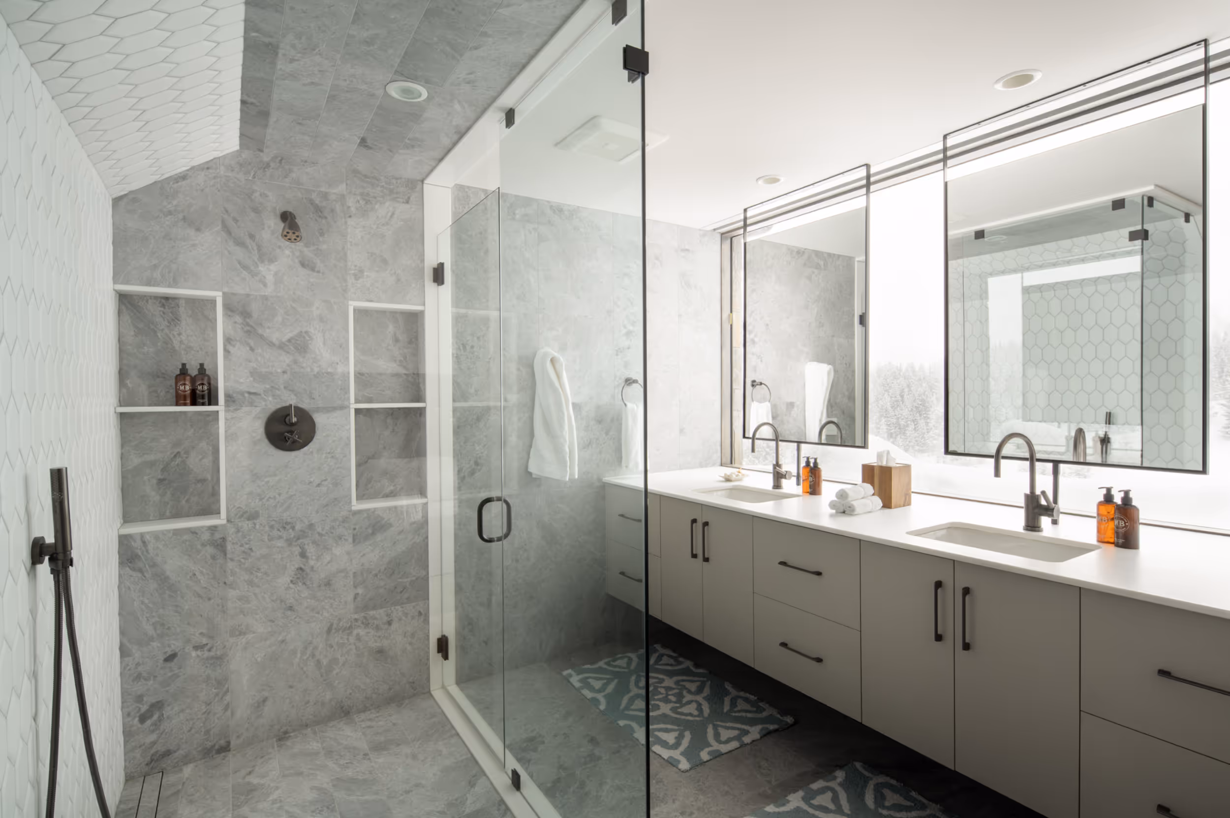A large, modern, light colored bathroom with his and hers sinksn
