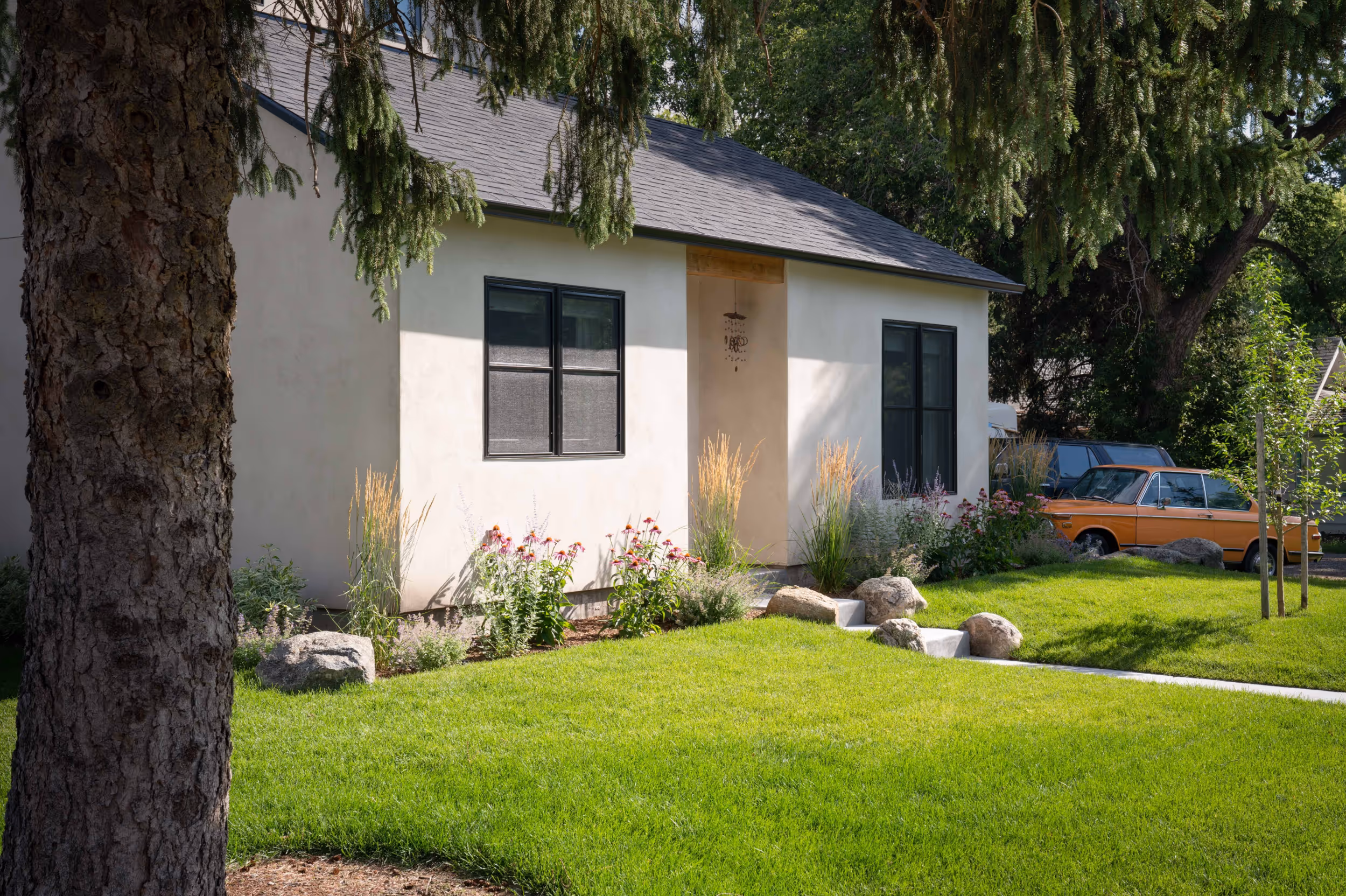A well manicured front lawn of a charming white house
