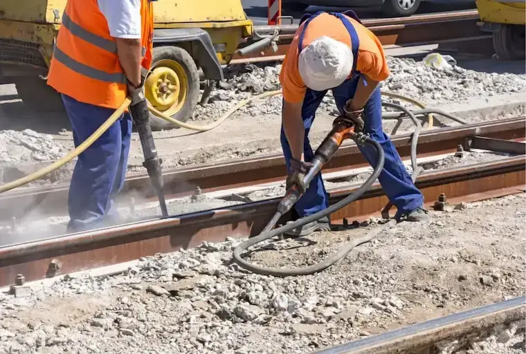 Demolition worker using tool to dismantle a wall