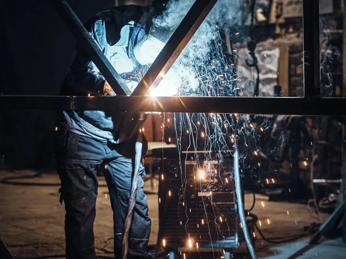 Metal worker cuts metal fence for BauBau