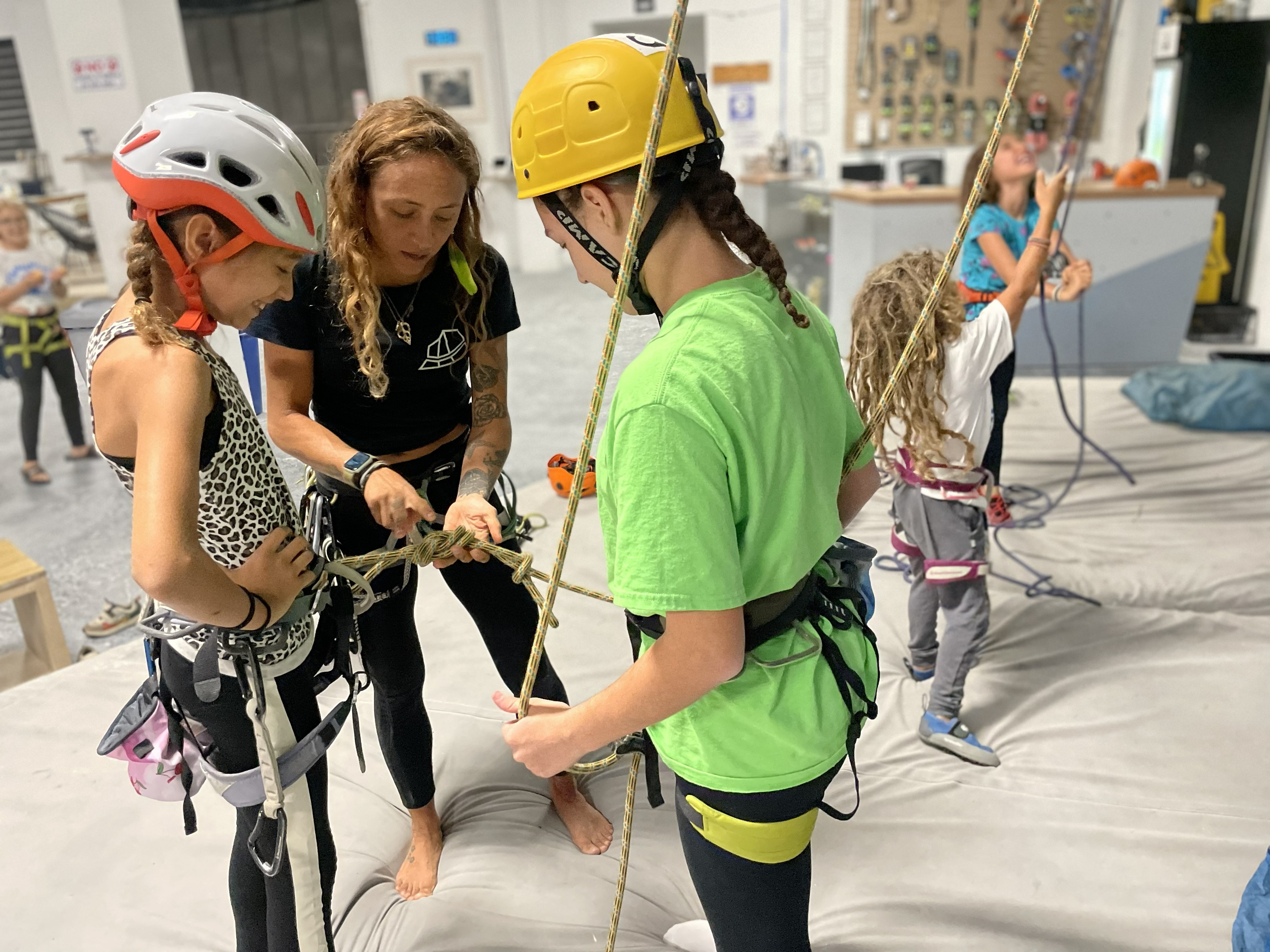 instructora demostrando como hacer un nudo a niñas