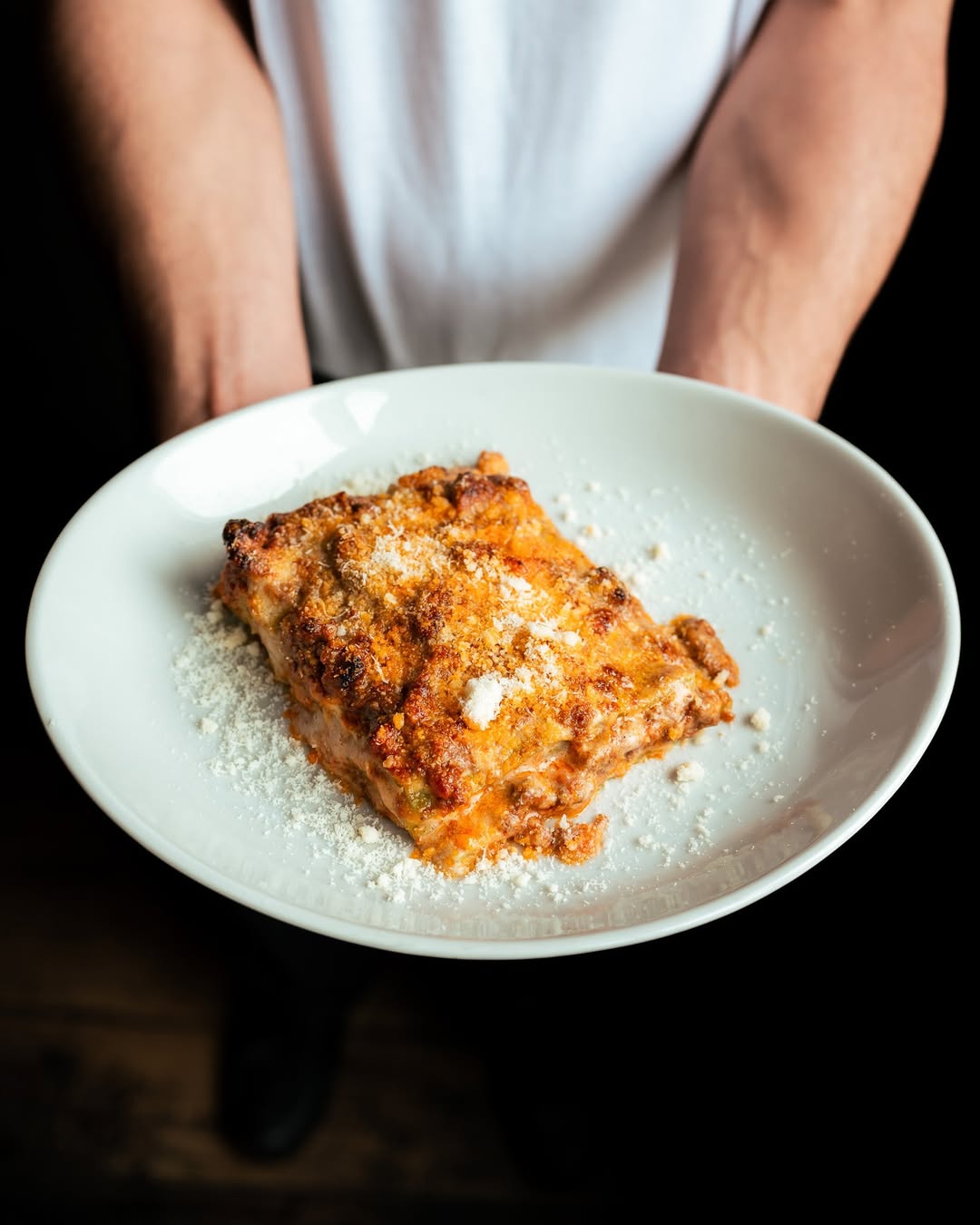 Spaghetti in cream sauce with shaved parmesan being served