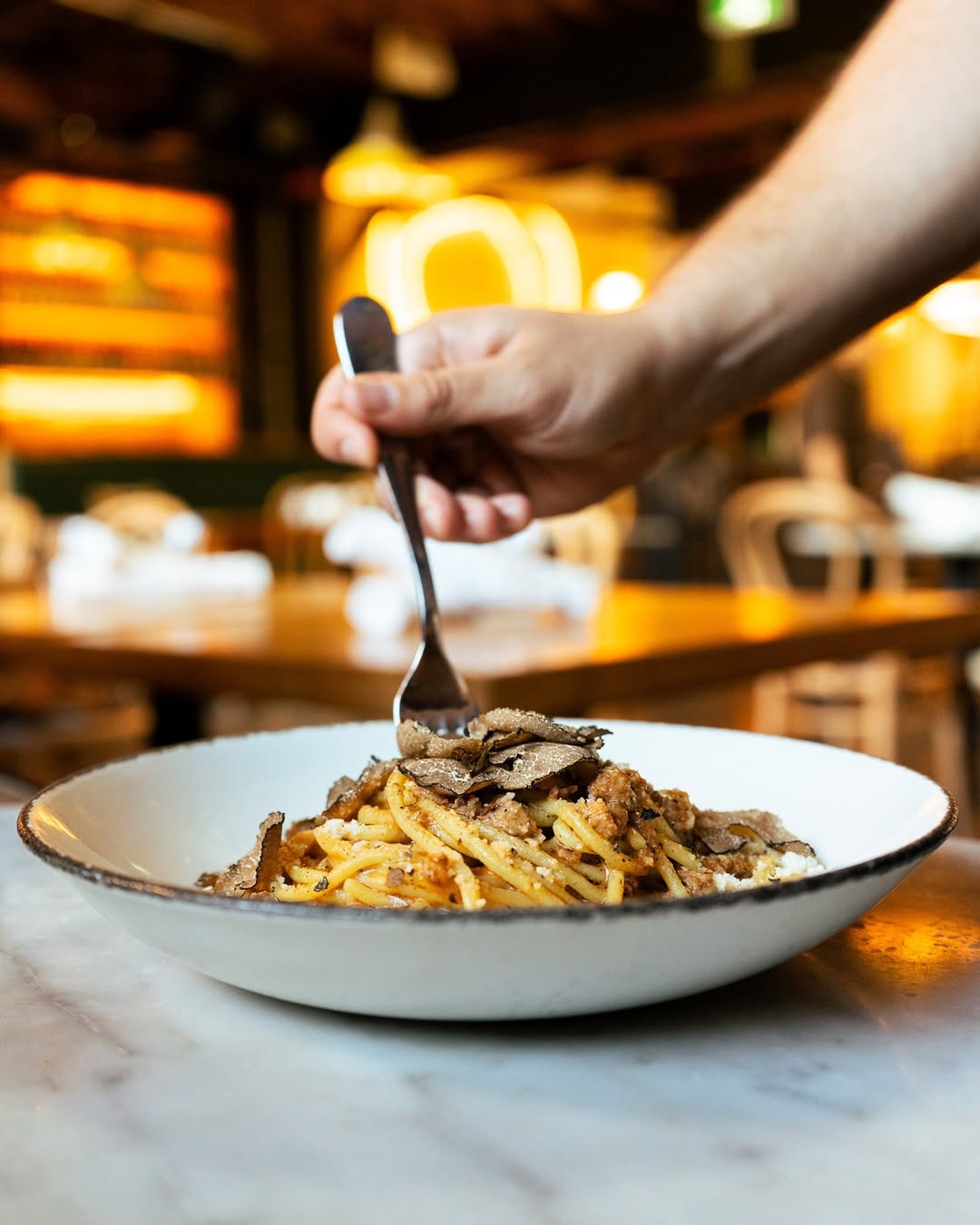 Fork twirling a forkful of pasta with shaved truffle