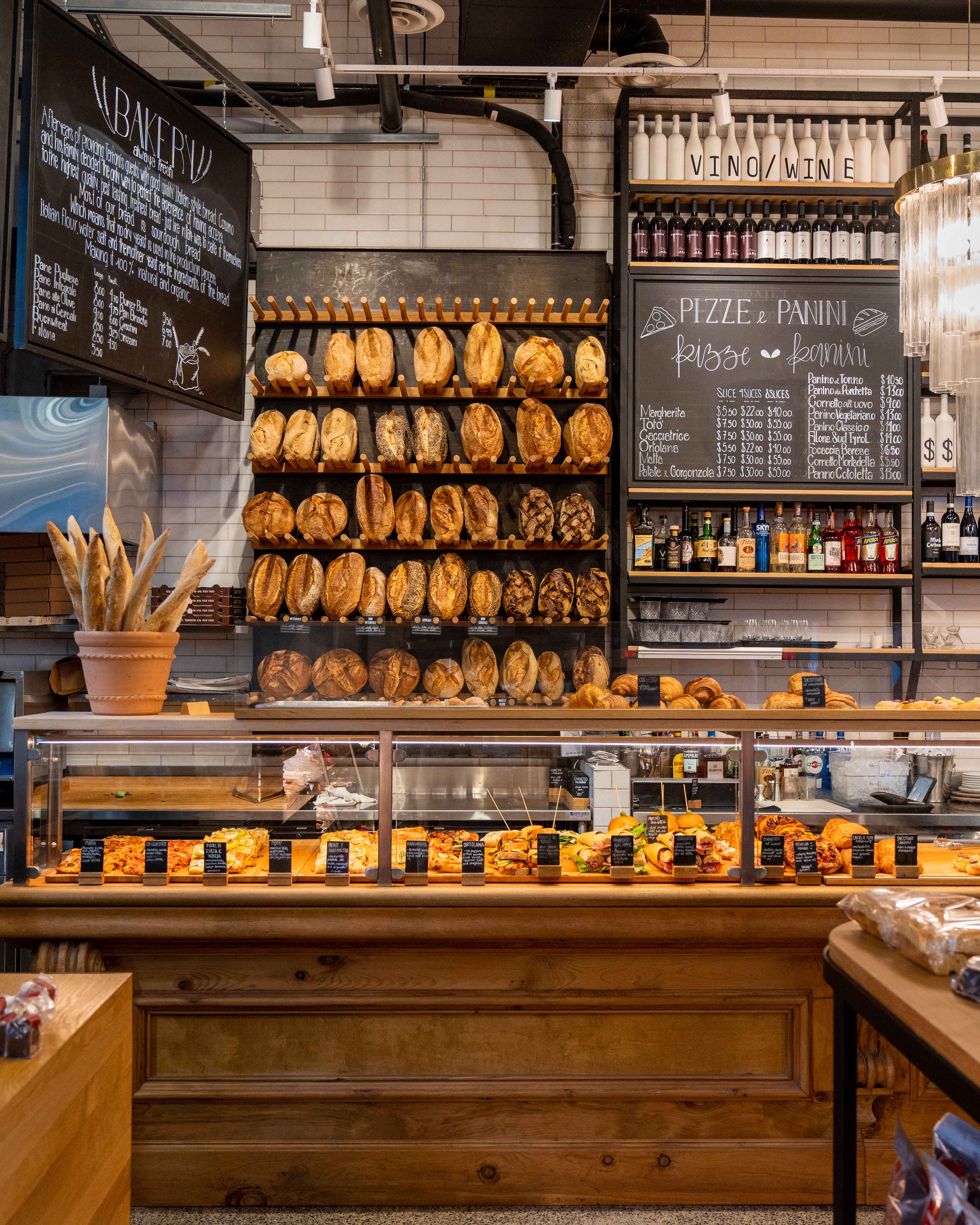 Bakery counter with bread shelves and a pizza and panini menu board