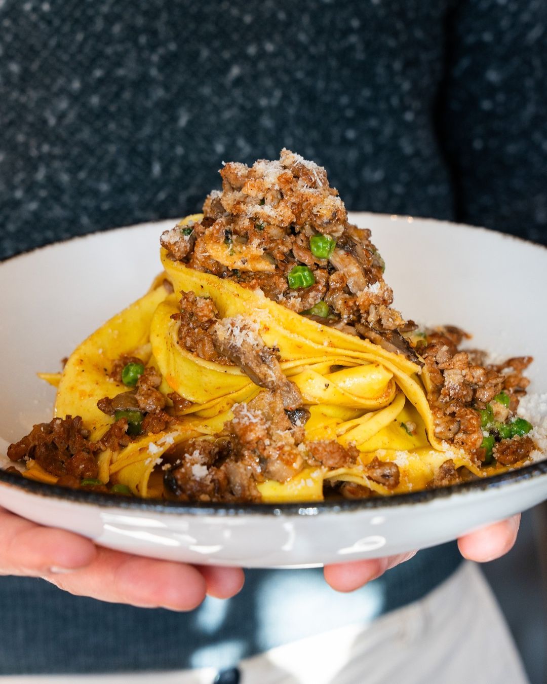 Pappardelle with sausage and mushroom ragù, peas, and grated parmesan