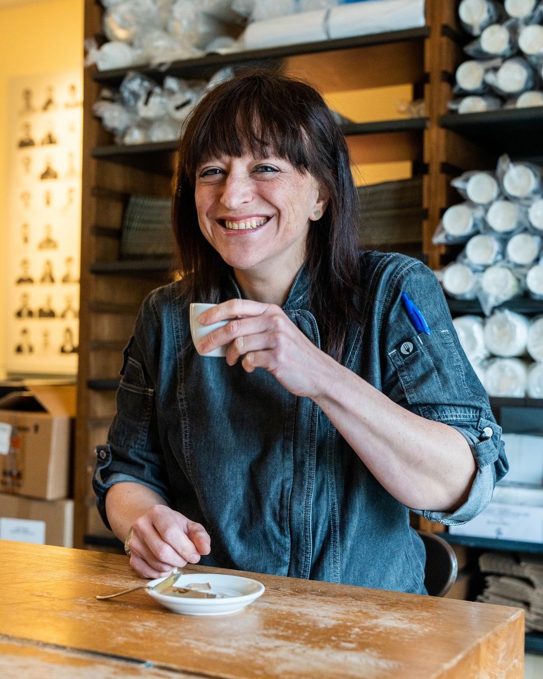 Chef Gio smiling and holding a small espresso cup at the counter
