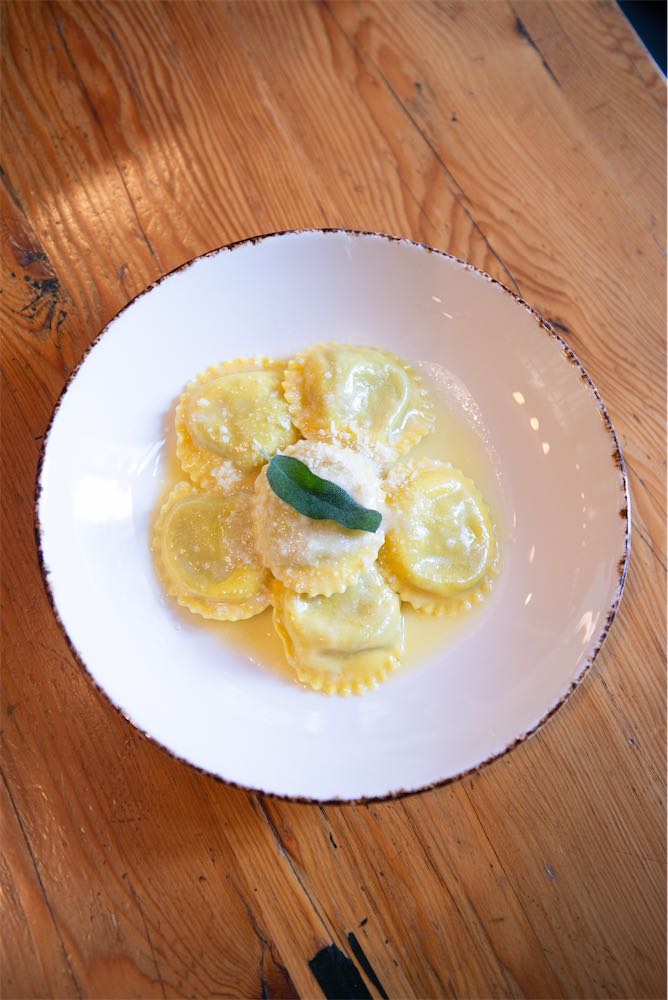 Overhead view of ravioli with butter, parmesan, and fried sage