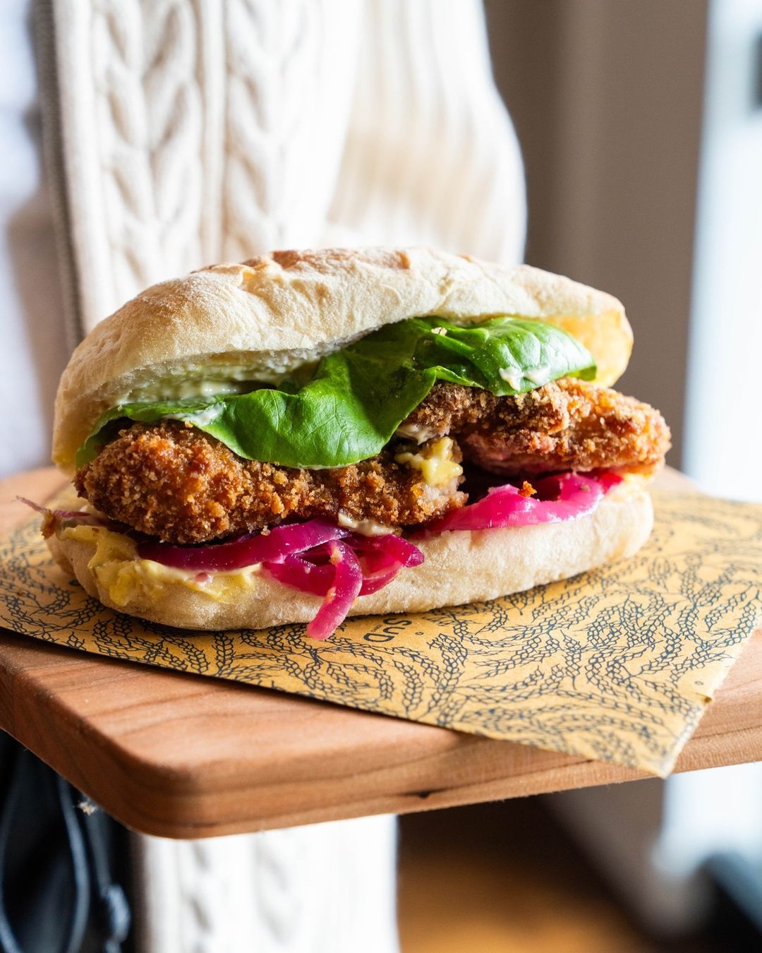 Breaded cutlet sandwich with pickled red onion and lettuce