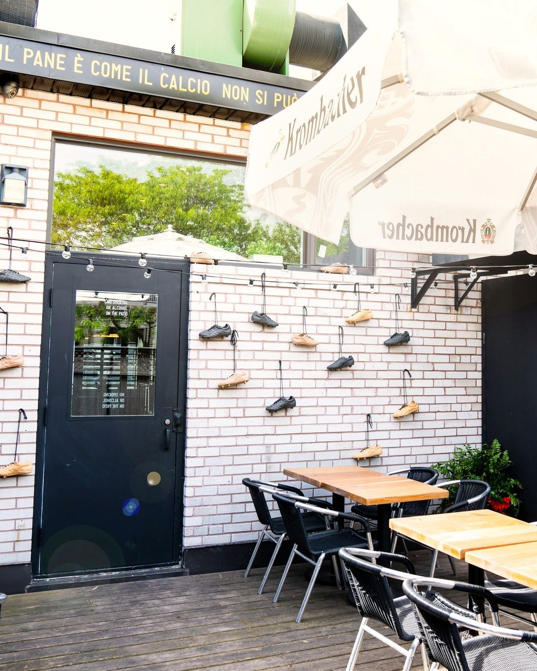 Patio with wood tables and soccer cleats hanging from the brick wall