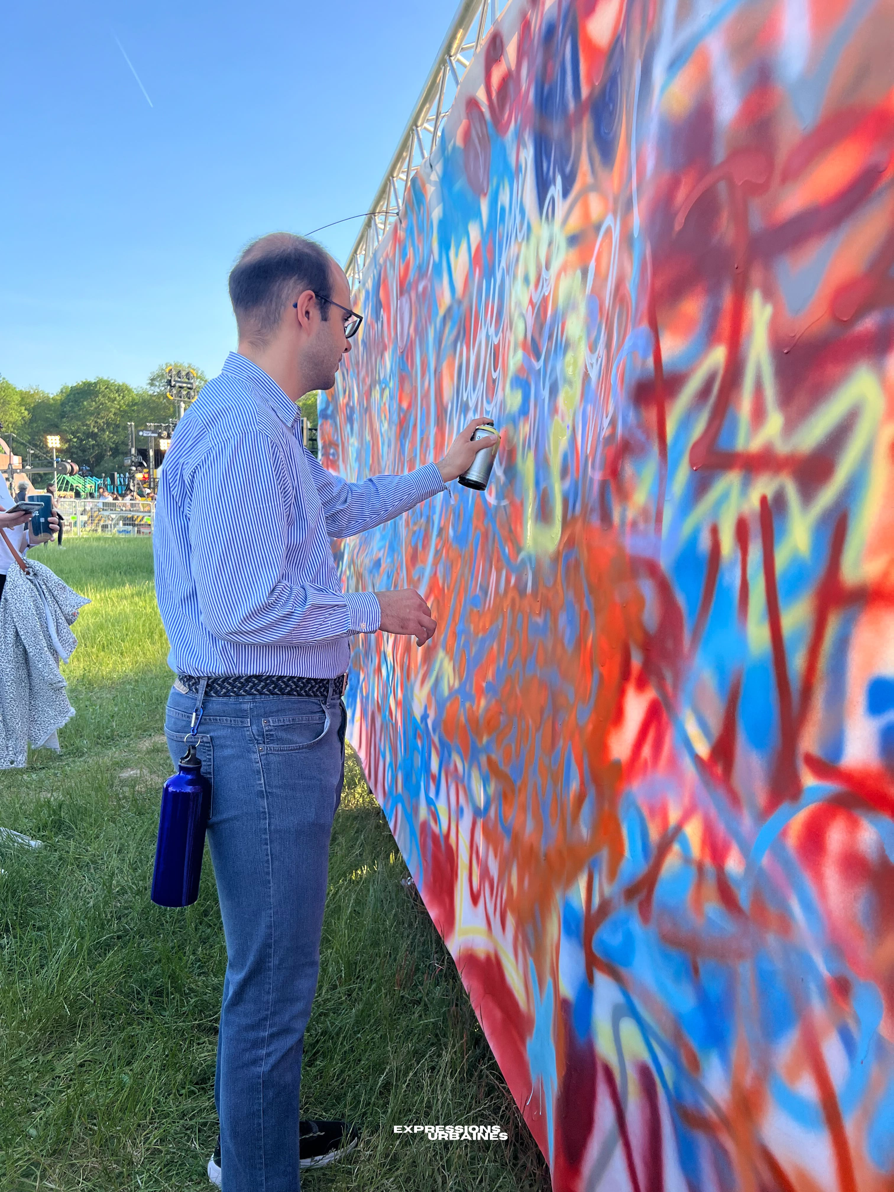 Atelier graff : participant peignant une fresque à la bombe en plein air